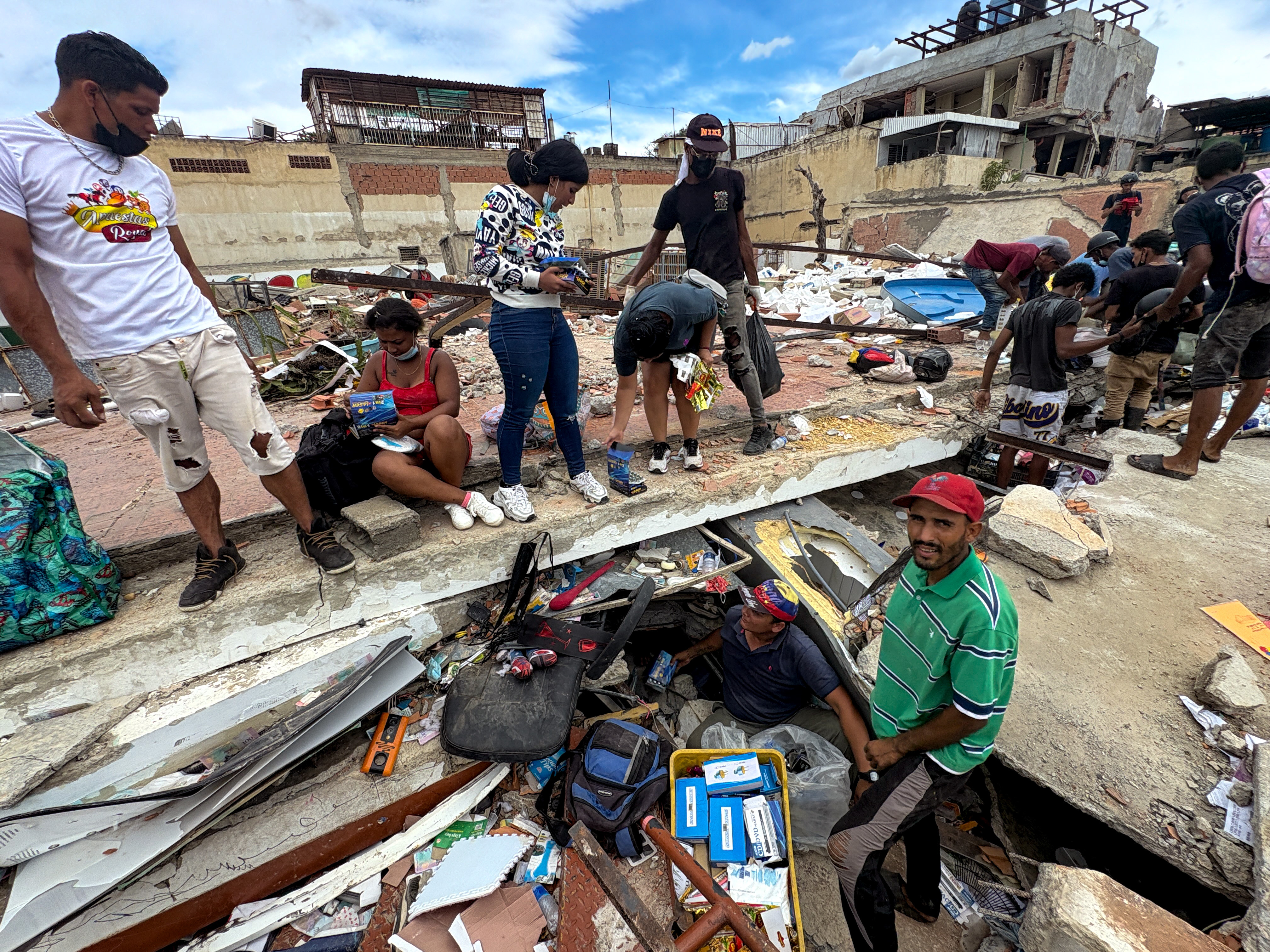 Locals look for the owner of a shop buried in the rubble of his store