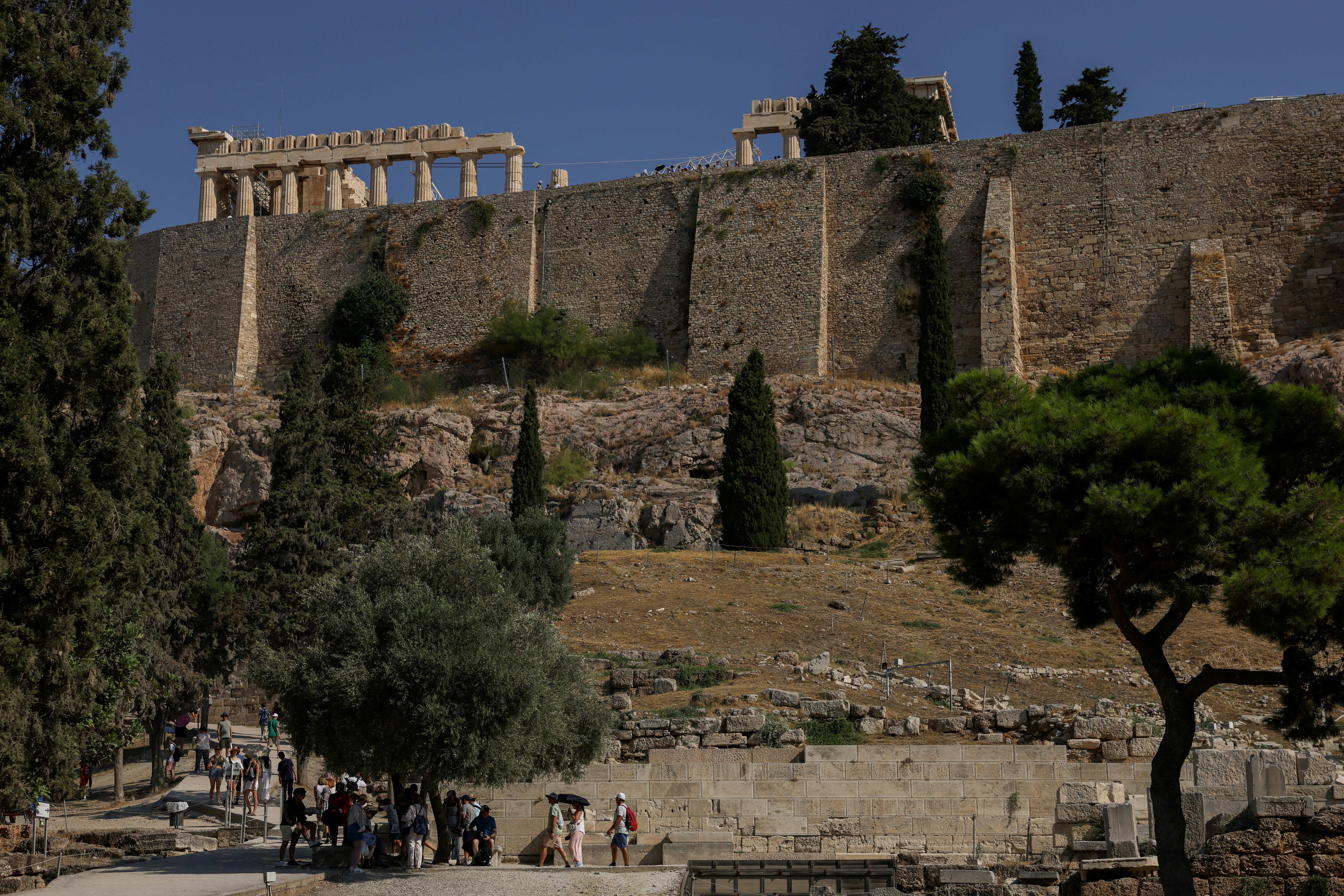 Tourists walk inside the Acropolis archaeological site near the location where two American tourists were stabbed in Athens, Greece, July 21, 2026. [Louiza Vradi/Reuters]