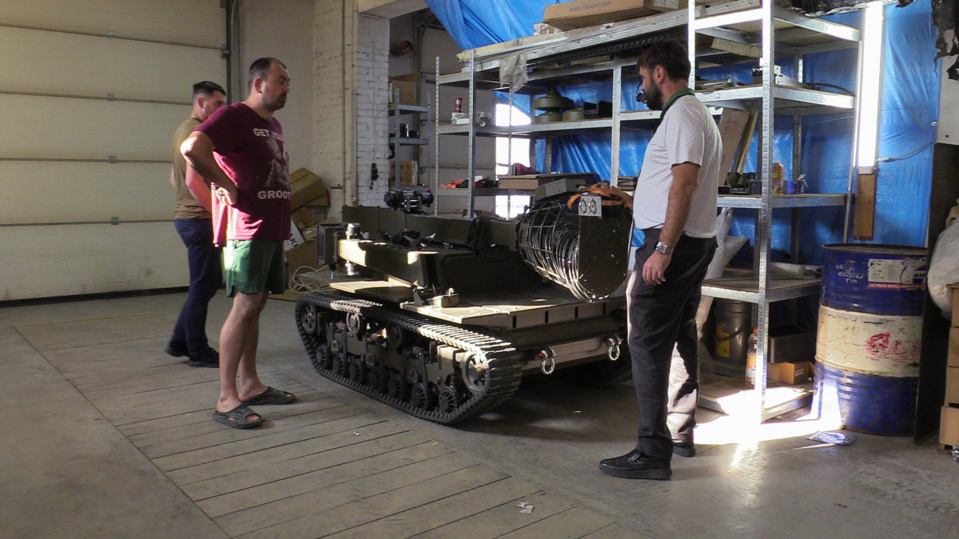 A man stands in a room with a robot