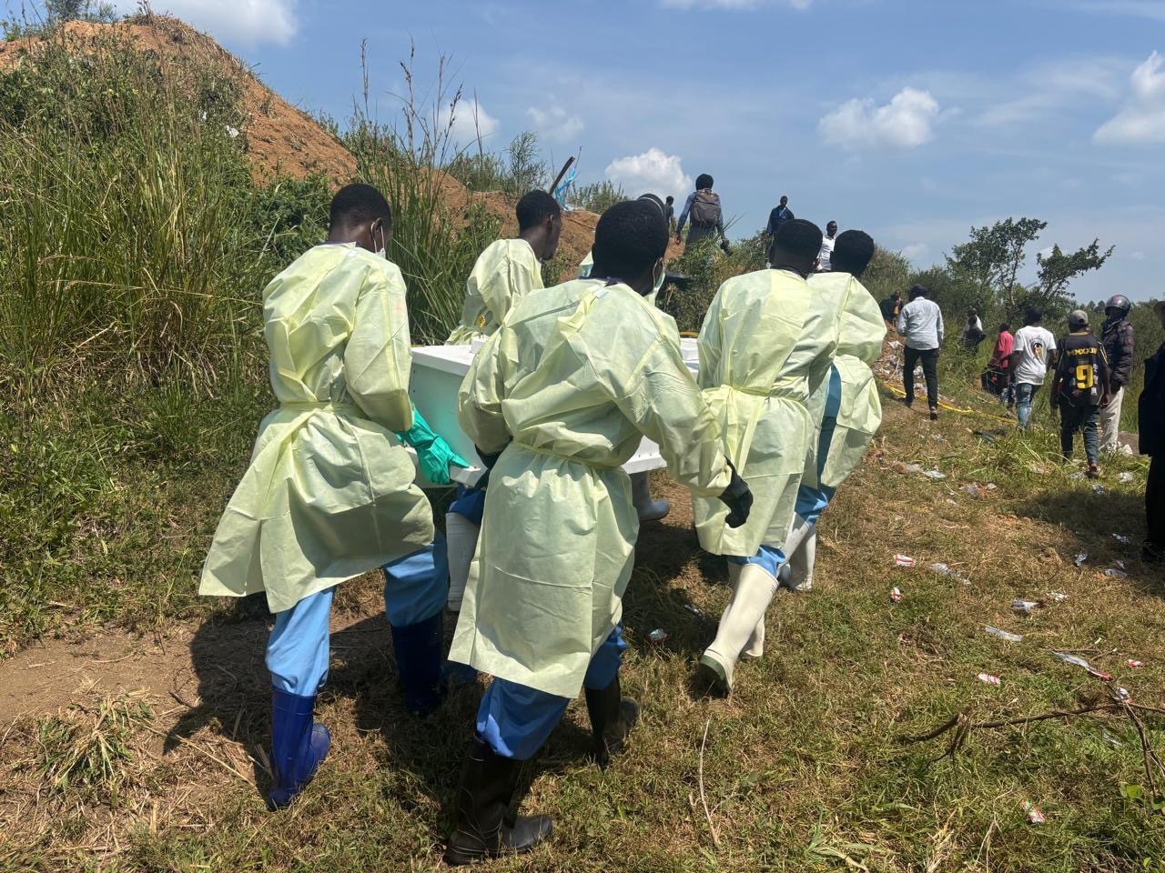 Red Cross volunteers and health workers carry a coffin up a hillside during the safe burial of a suspected Ebola victim on the outskirts of Bunia.
