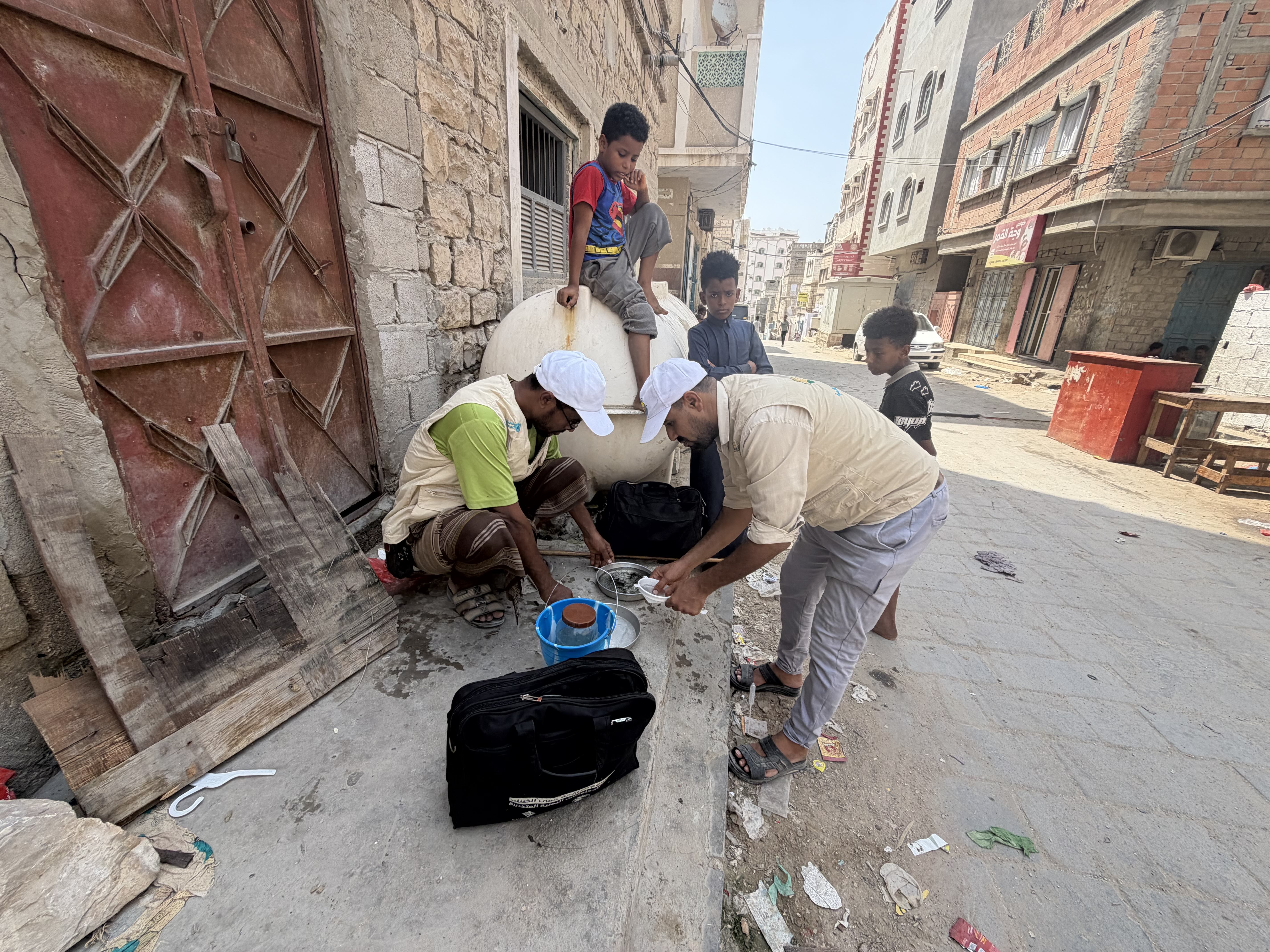 Salem Bin Shabz , an insect surveillance officer, and a colleague collect water samples from an uncovered storage tank in Mukalla after identifying mosquito larvae that transmit dengue fever and malaria.