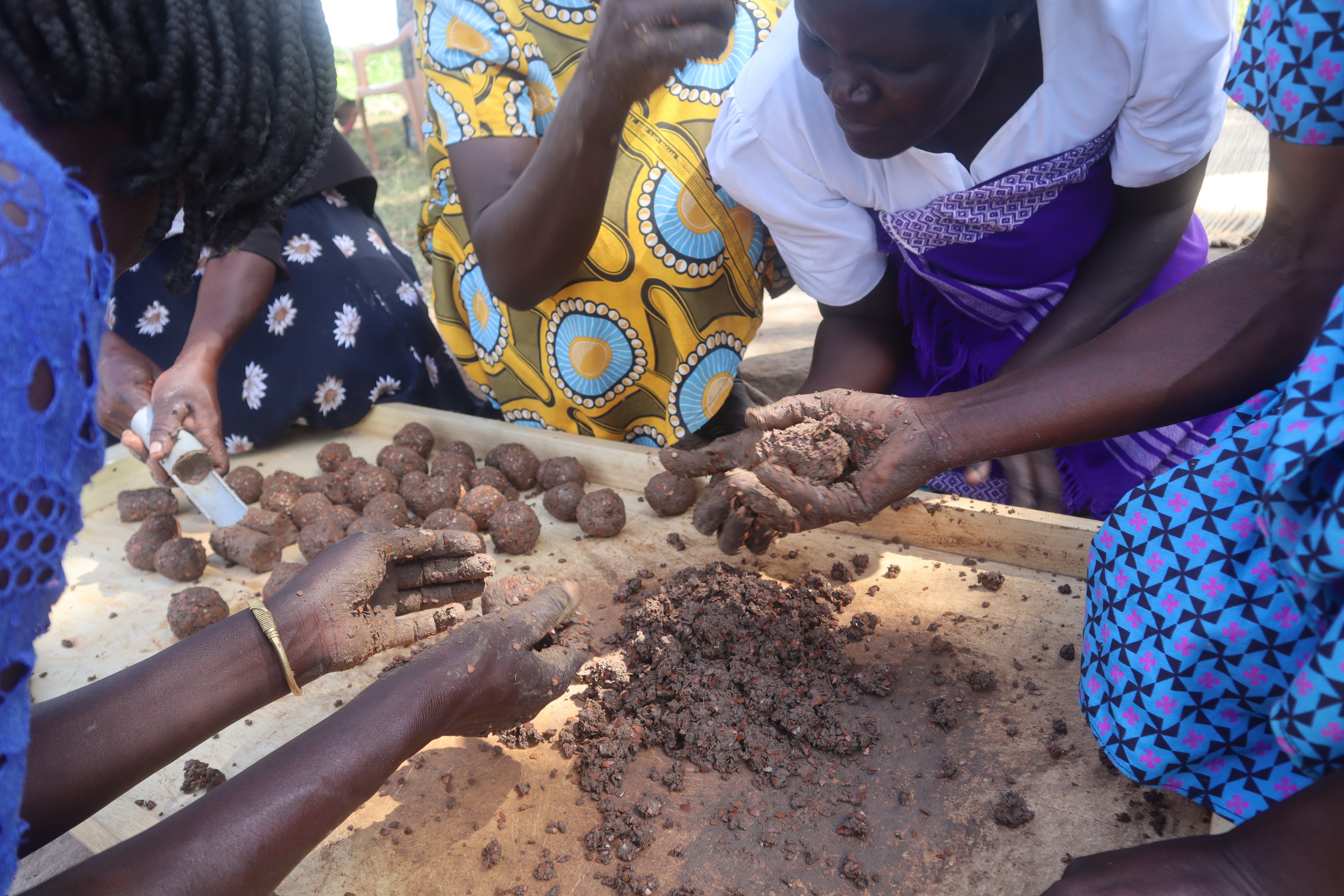 Some women mould briquettes made from shea husks into different shapes. Photo by John Okot.