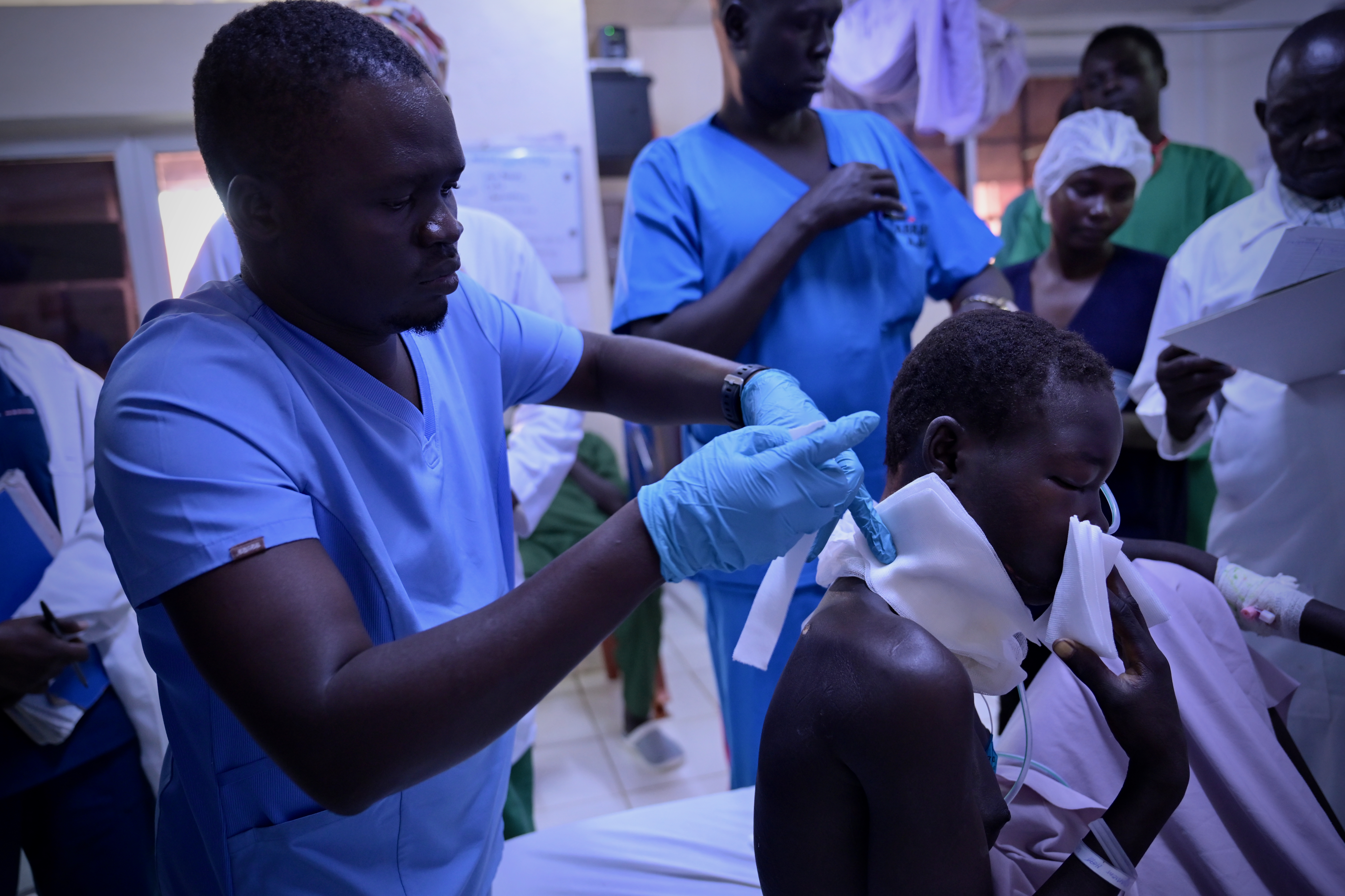 A nurse treats a gunshot wound victim at Juba Military Hospital after the patient was evacuated from Ganyiel to Juba by the International Committee of the Red Cross