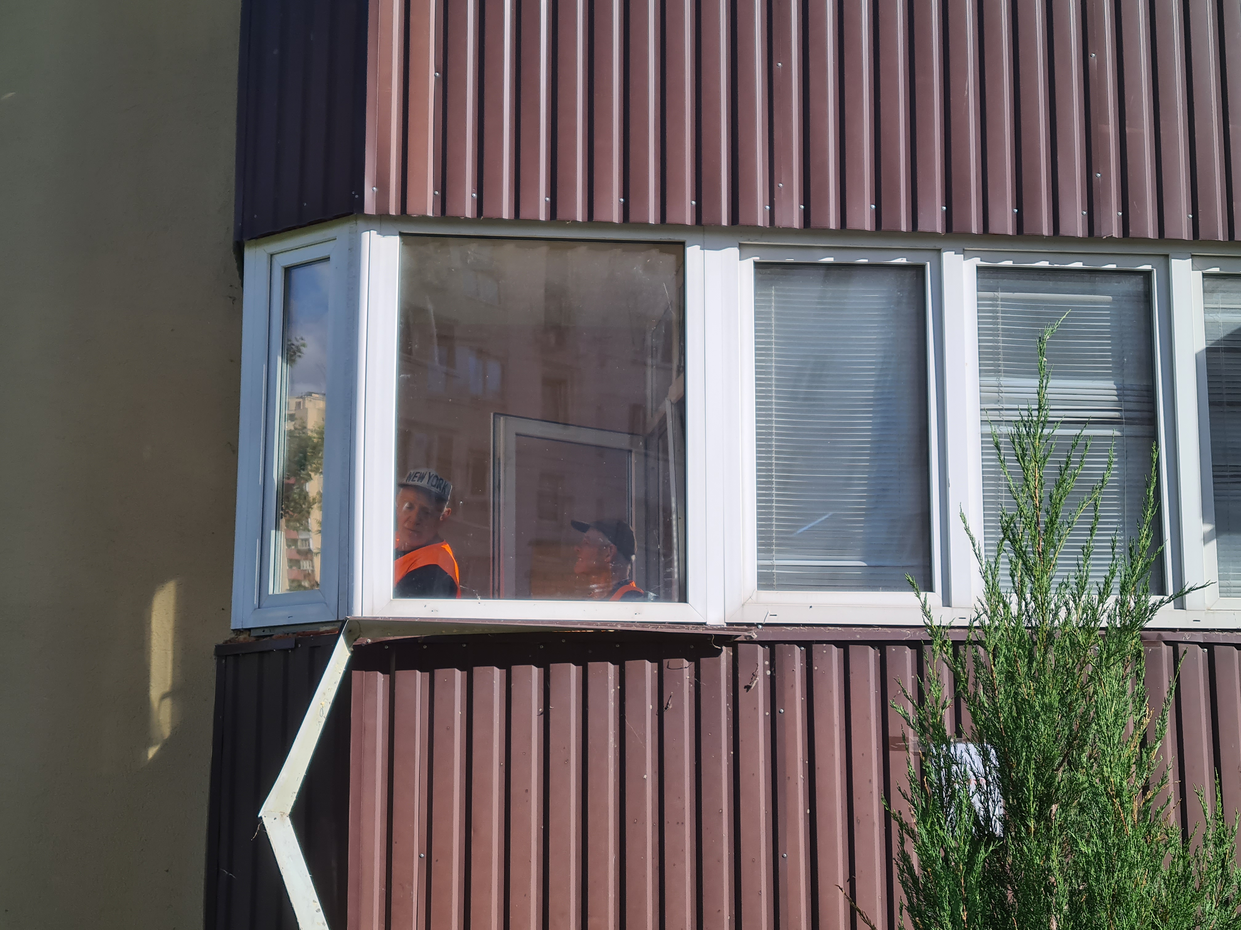 Volunteers with Dobrobat examine shattered windows-1784208374