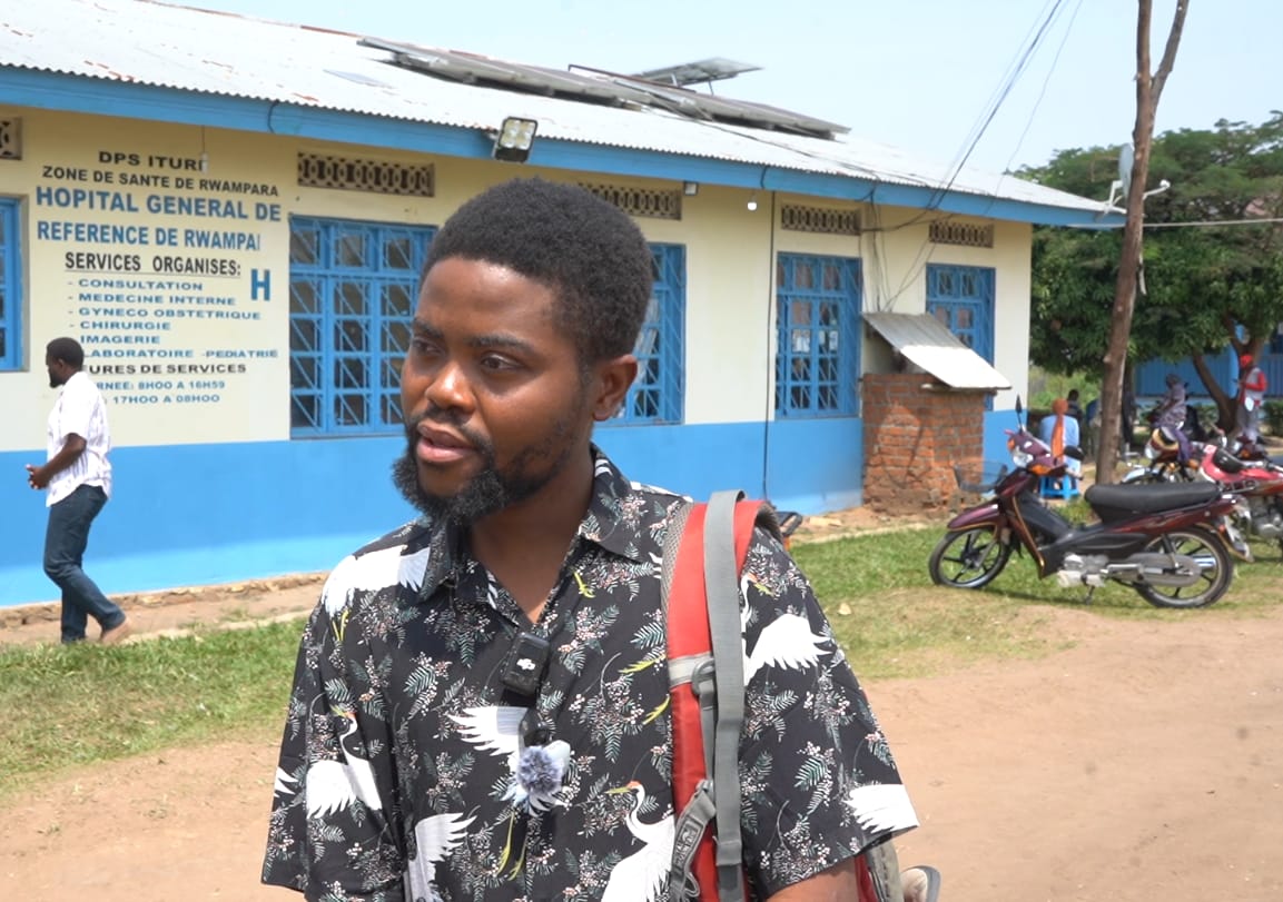 Maneba, an epidemiologist working on the DRC response team, stands outside the Rwampara General Hospital in Ituri. He is one of several who have not been paid since the outbreak began [Prosper Heri Ngorora/Al Jazeera]