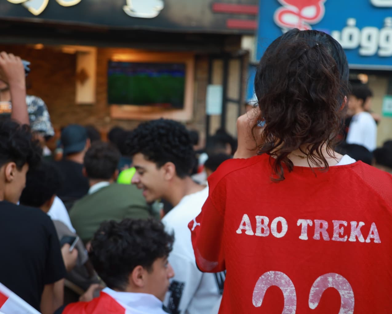 A fan wearing the shirt of legendary Egypt forward Mohamed Aboutrika watches the match in Giza, Egypt [Al Jazeera]