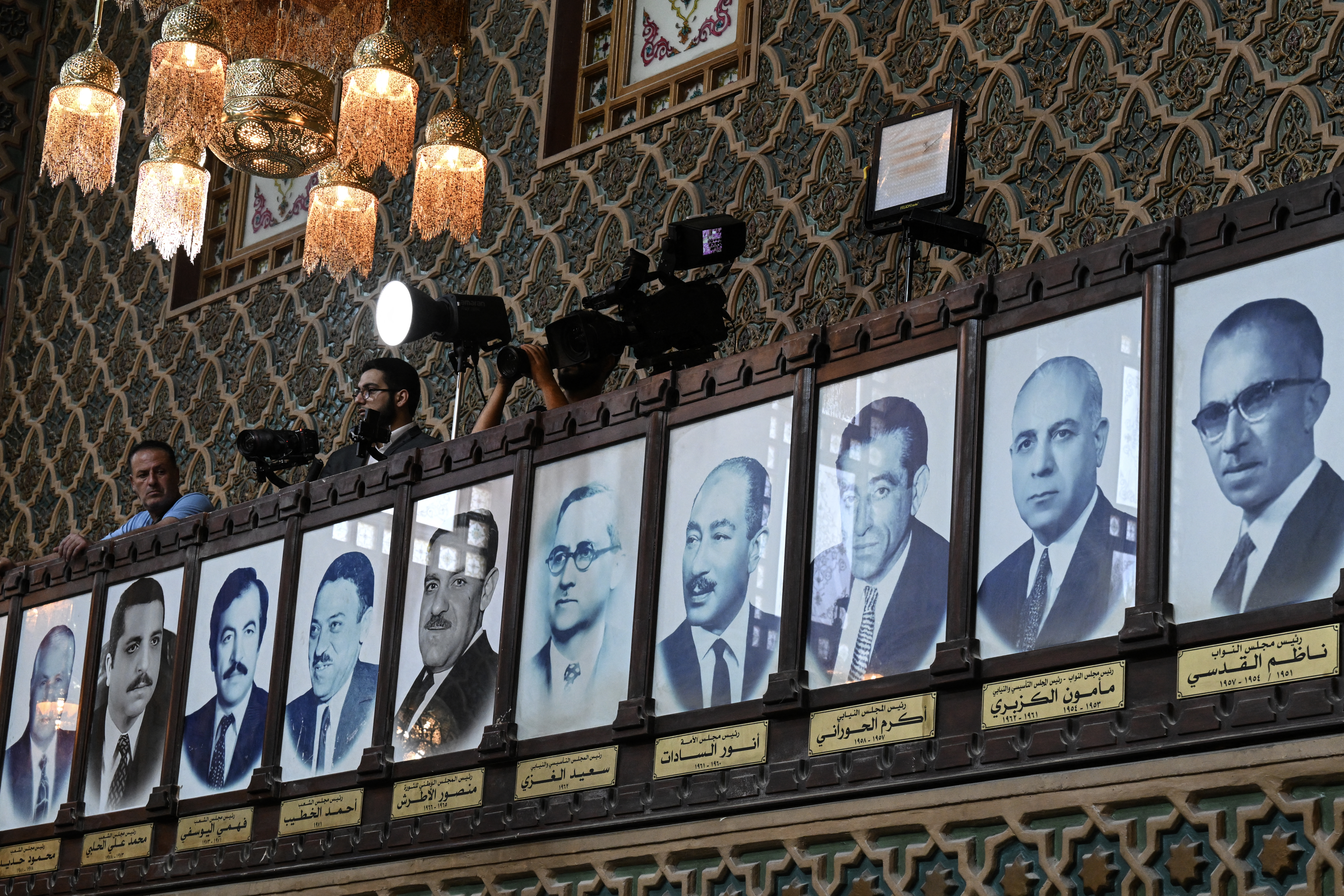 Portraits of the former speakers of Syrian parliament, including former Egyptian President Anwar Sadat (fourth from right), who served as chair of the Council of Nations under the United Arab Republic era, are displayed at the parliament in Damascus [AFP]