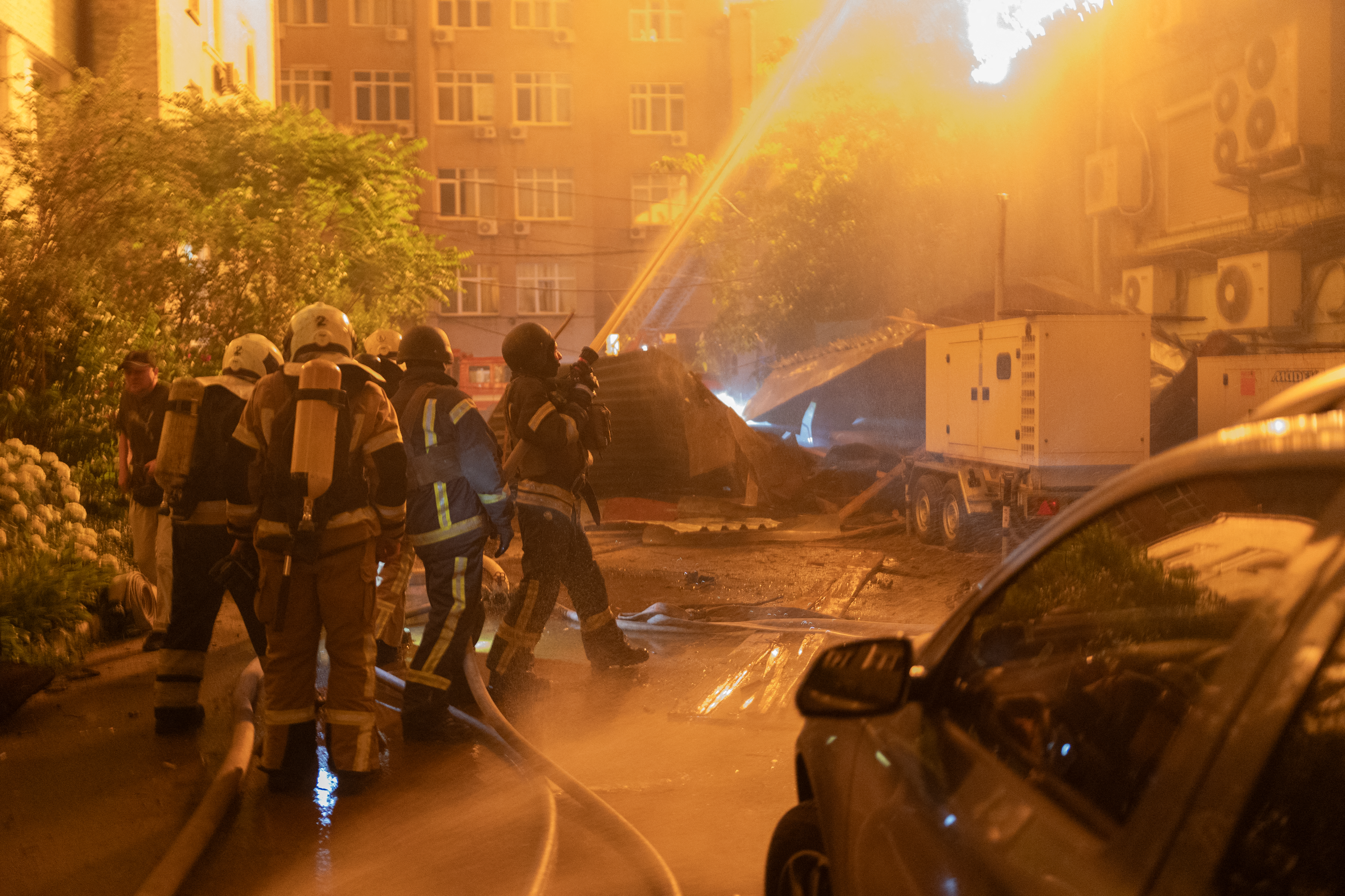 An explosion is seen after a Russian drone strikes a building as Ukrainian firefighters battle a fire in another building previously hit by a drone during a Russian air attack on Kyiv, early on July 2, 2026.