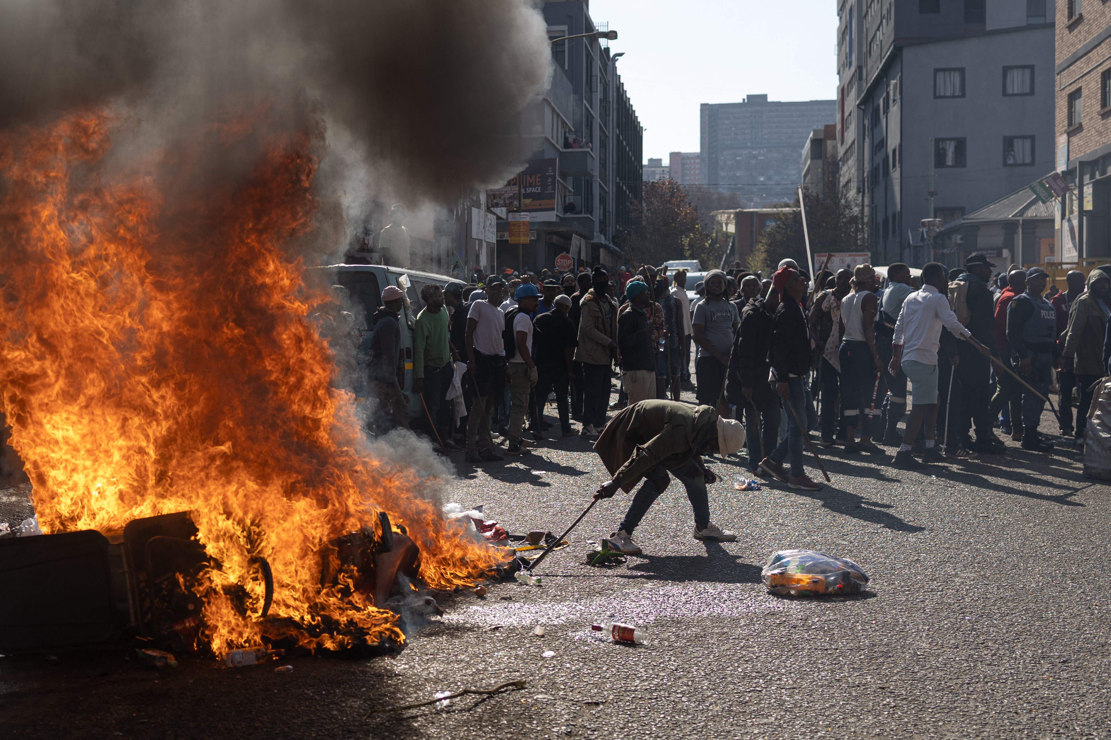 Protesters gather outside a building they believe is occupied by undocumented foreign nationals during a demonstration by the "March and March" and Operation Dudula movements marking an unofficial deadline set by citizen-led groups for undocumented foreign nationals to leave South Africa, in Johannesburg, on June 30, 2026.