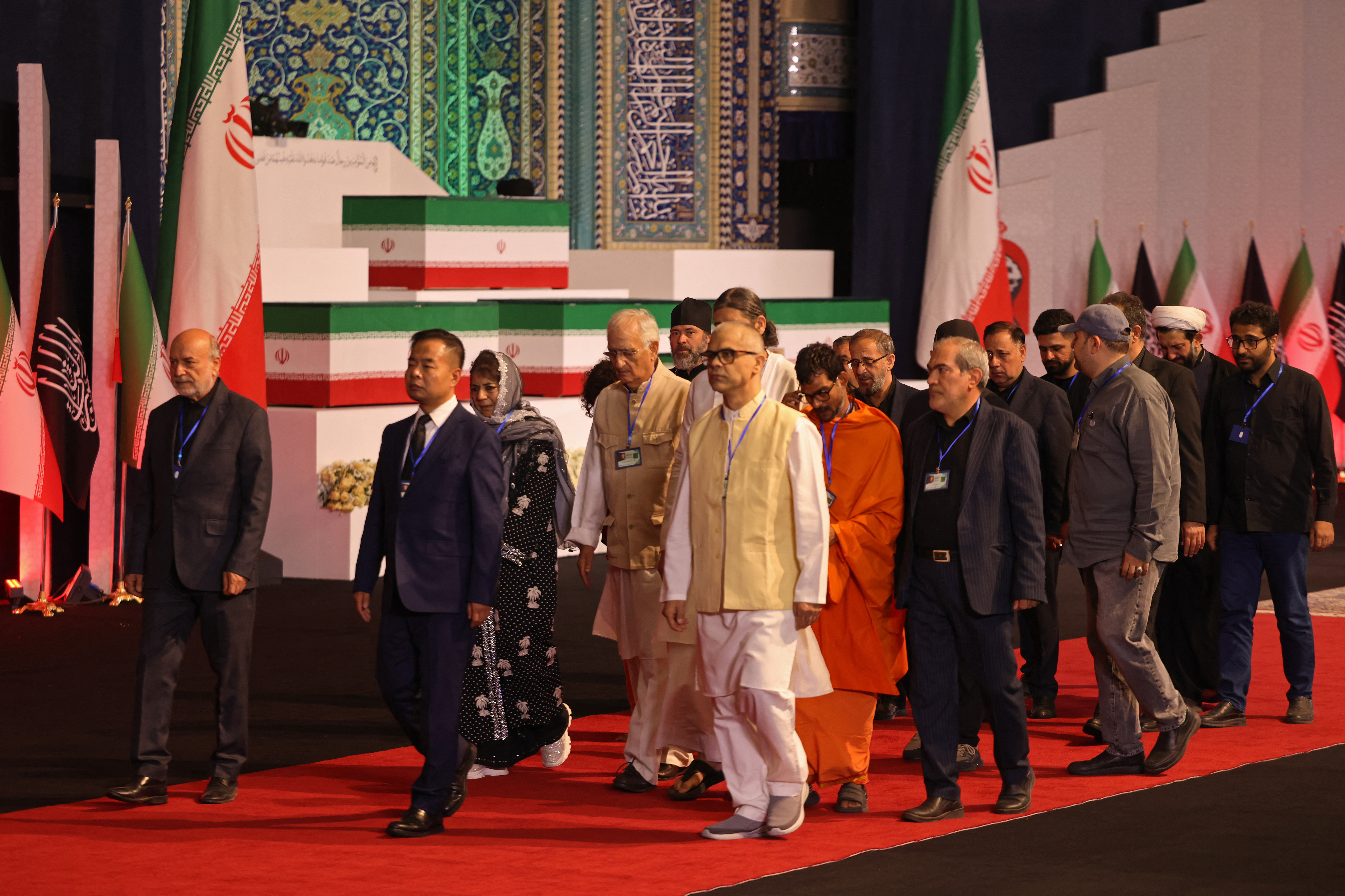 Members of the Indian delegation walk past the coffins.