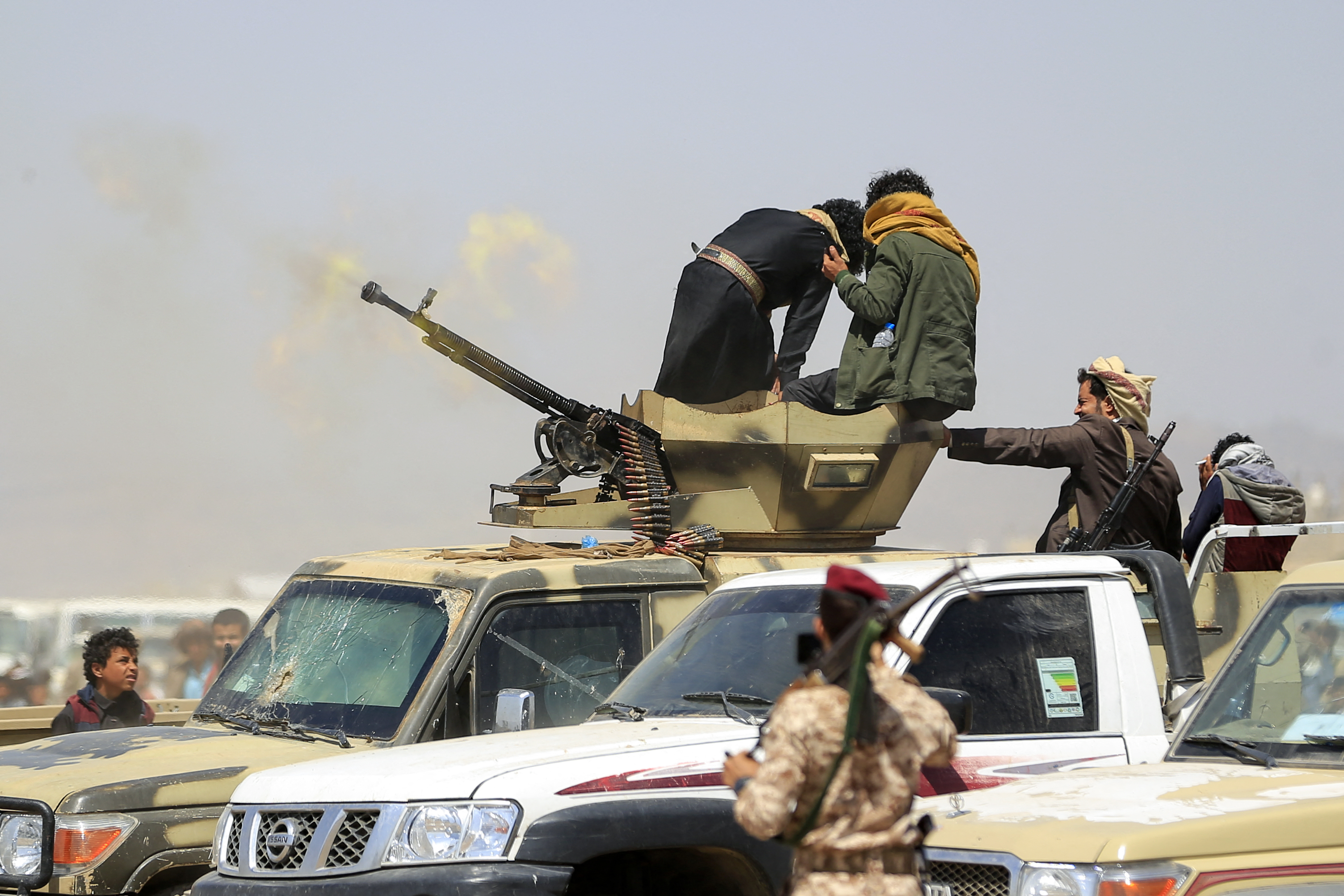 Soldiers fire a heavy machinegun.