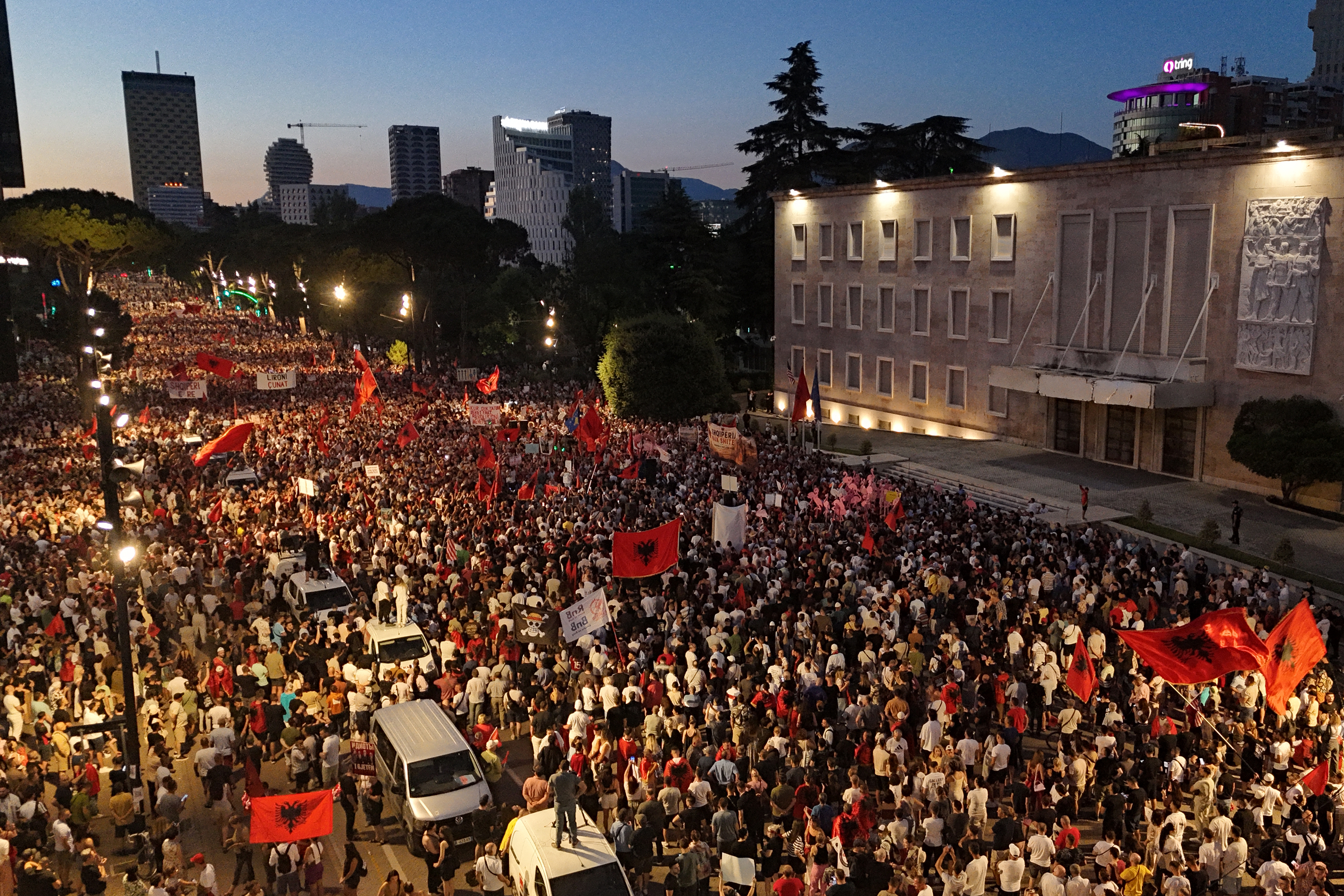This aerial photograph shows protesters as they demonstrate in front of the Albanian Prime Minister's Office against the construction of a luxury resort near a protected natural area on Albania's southern coast, in Tirana, on July 4, 2026.