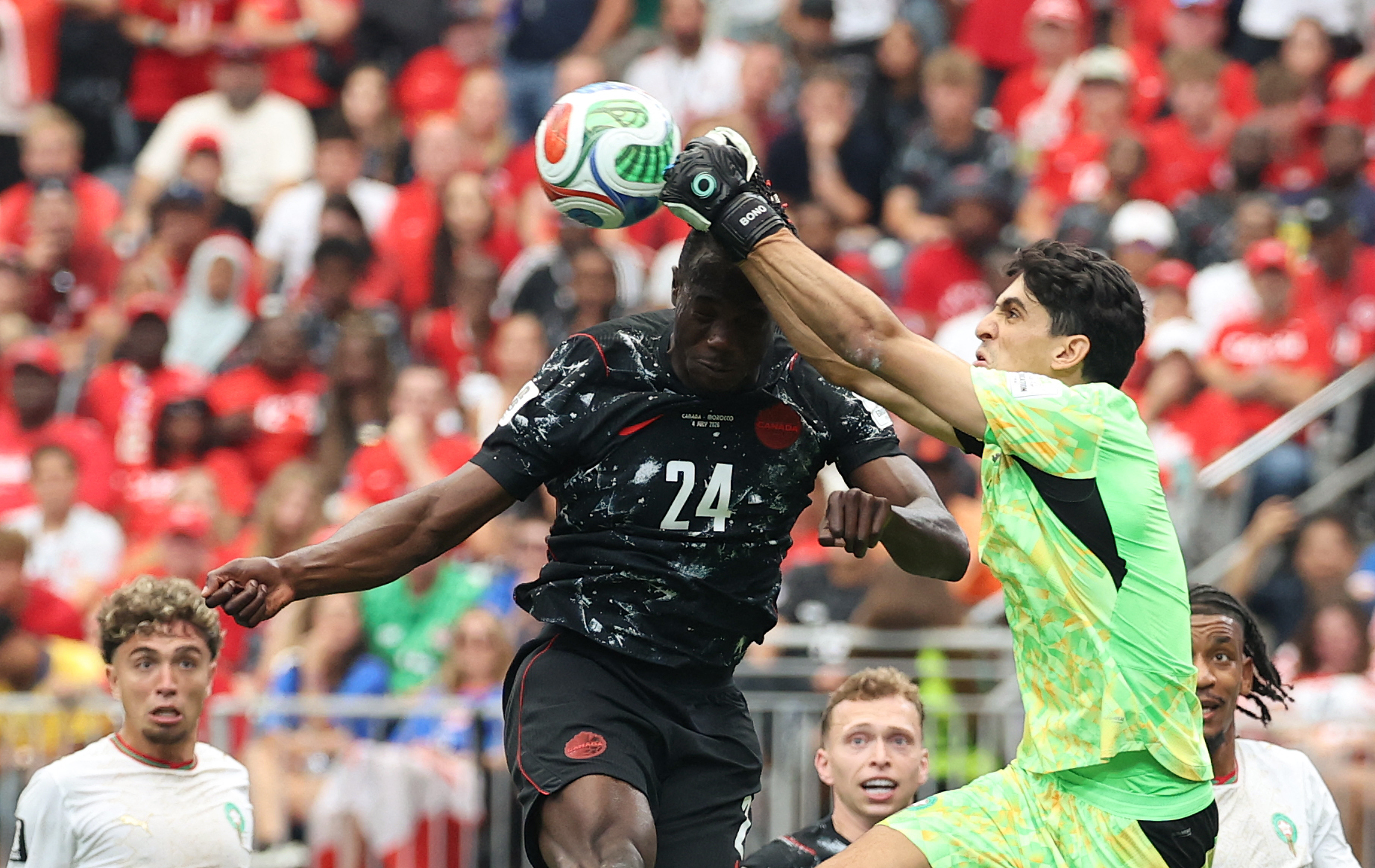 TOPSHOT - Morocco's goalkeeper #01 Yassine Bounou clears the ball past Canada's forward #24 Promise David during the 2026 World Cup round of 16 football match between Canada and Morocco at the Houston Stadium in Houston on July 4, 2026.