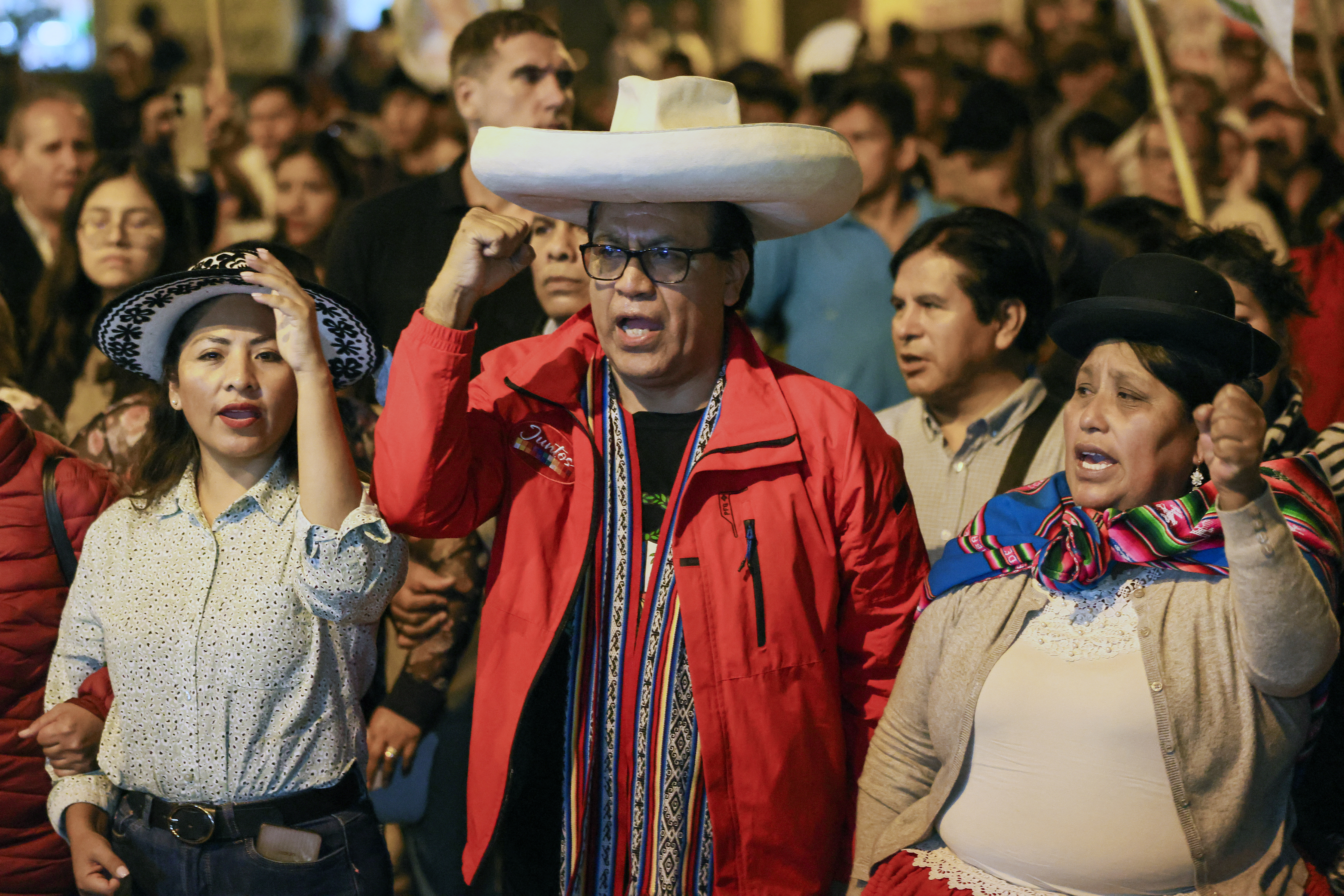 Peru's presidential candidate for the Juntos por el Peru party, Roberto Sanchez, walks flanked by his first vice-presidential candidate Anali Marquez (L) and second vice-presidential candidate Brigida Curo during a protest march in Lima on June 27, 2026.