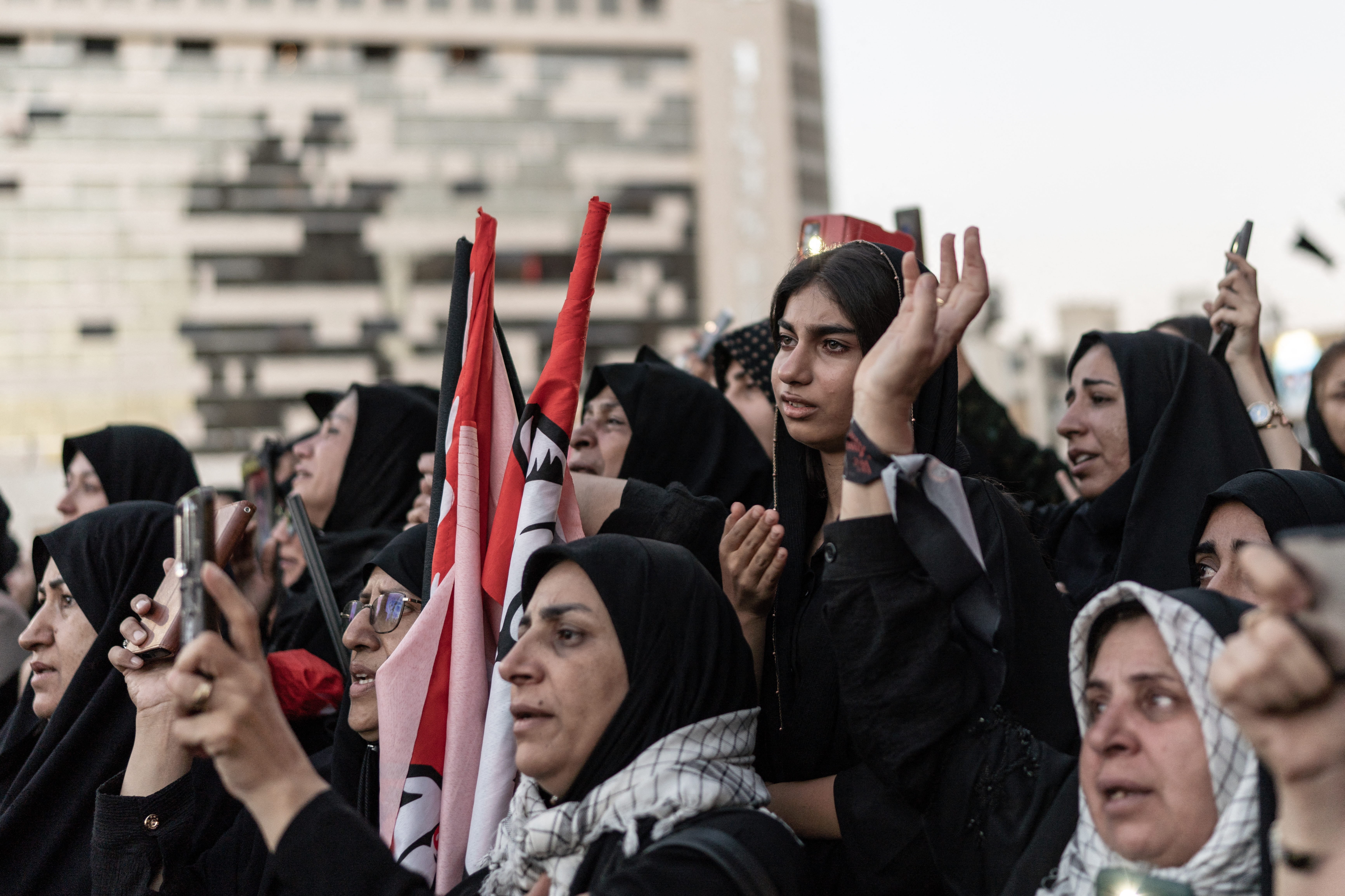 Women mourners attend a funeral.