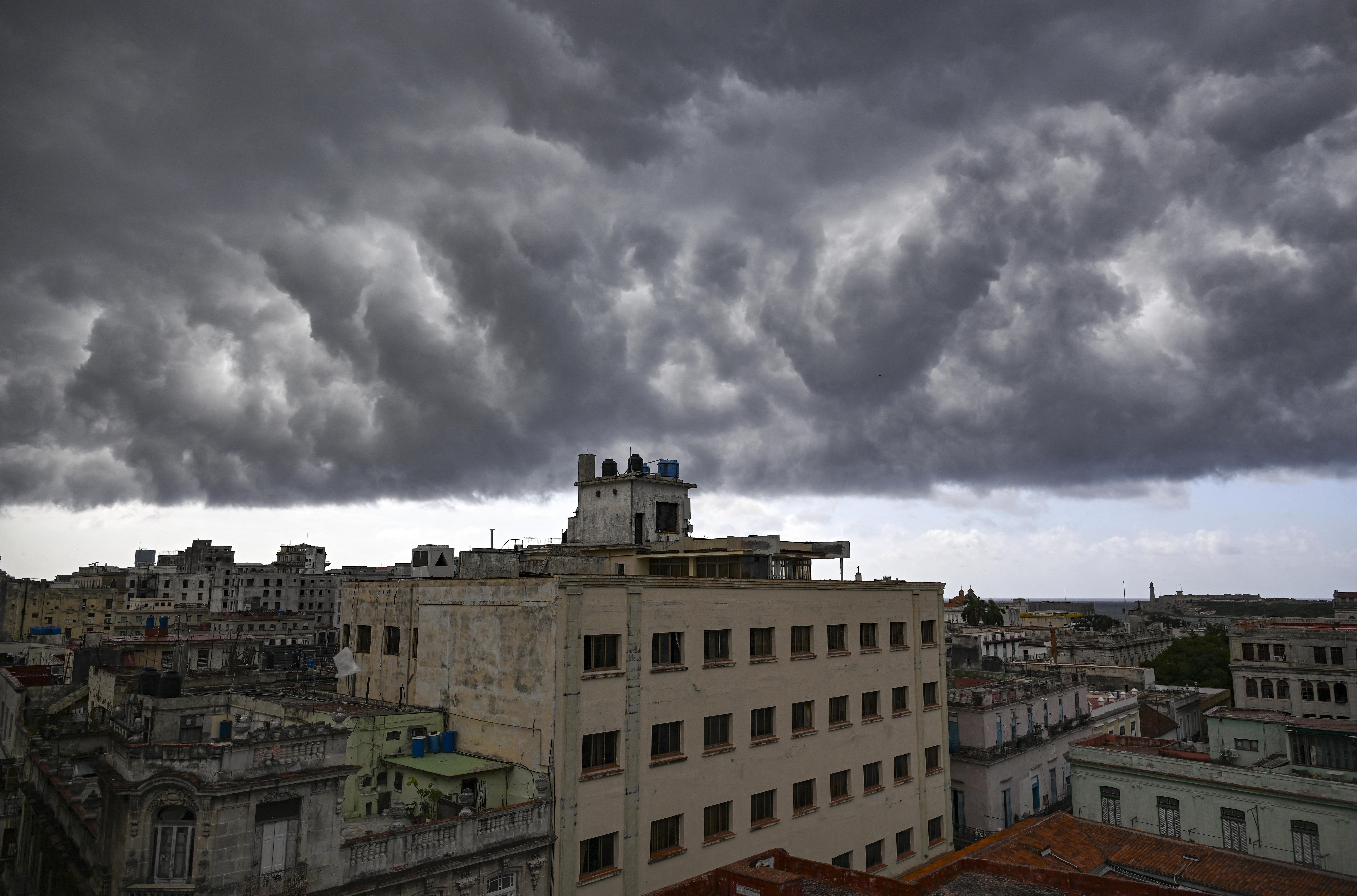 Large clouds loom over buildings in the Old Havana neighbourhood during a power cut in Havana on July 9, 2026. (Photo by YAMIL LAGE / AFP)