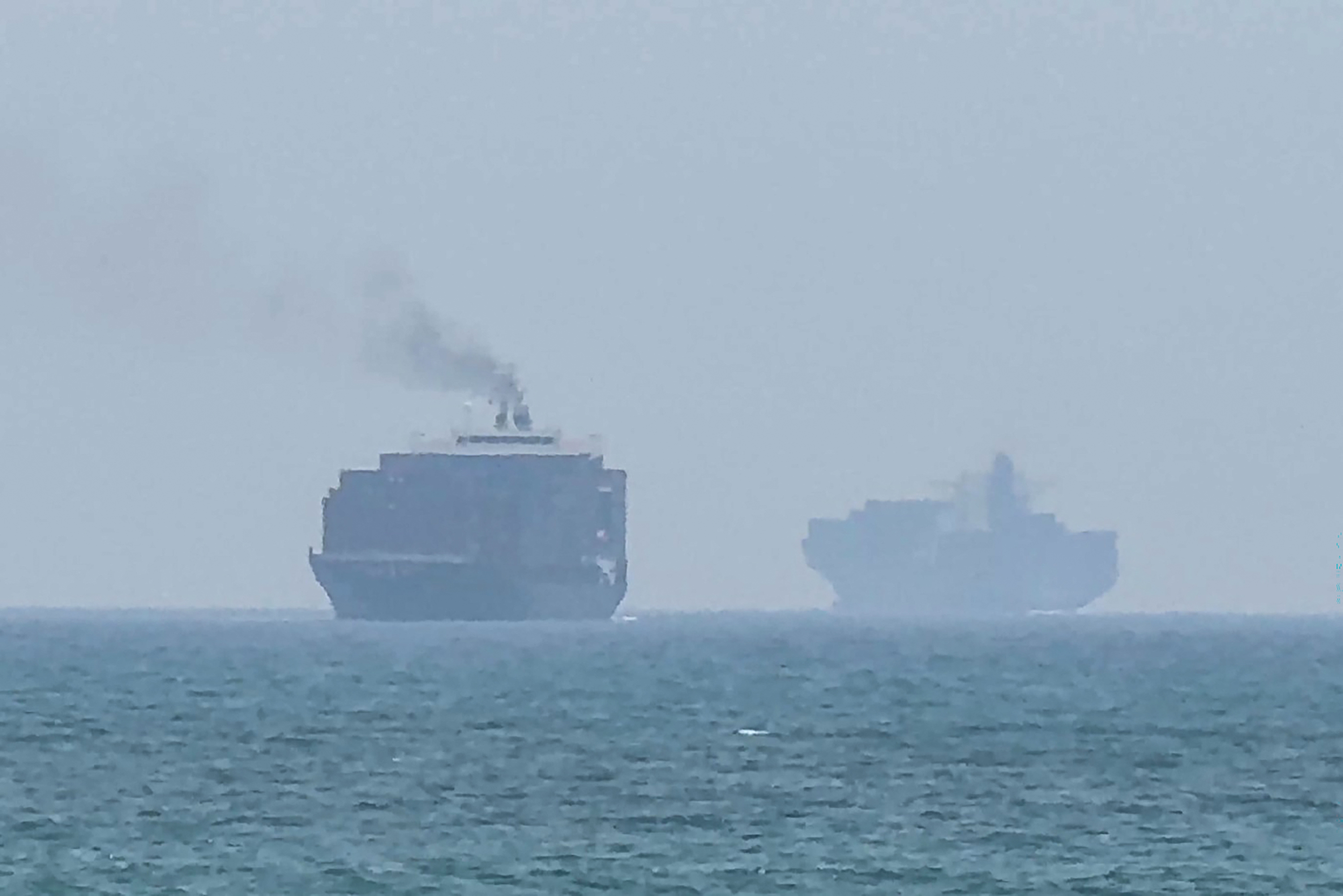 Cargo ships anchored at sea off the coast of Khor Fakkan in the United Arab Emirates