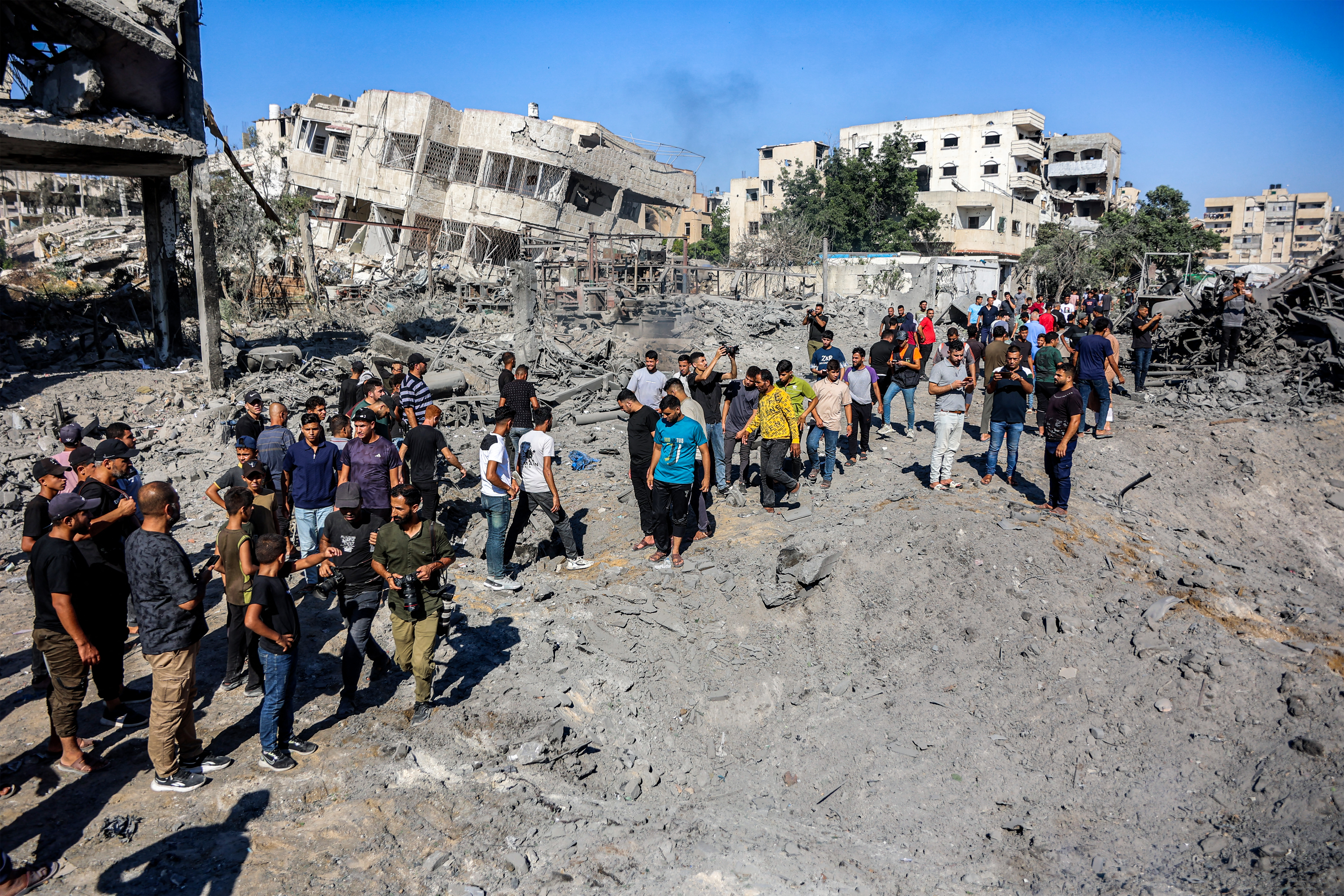 People gather by the rubble of destroyed buildings following an Israeli strike on an industrial area in Gaza City on July 12, 2026.