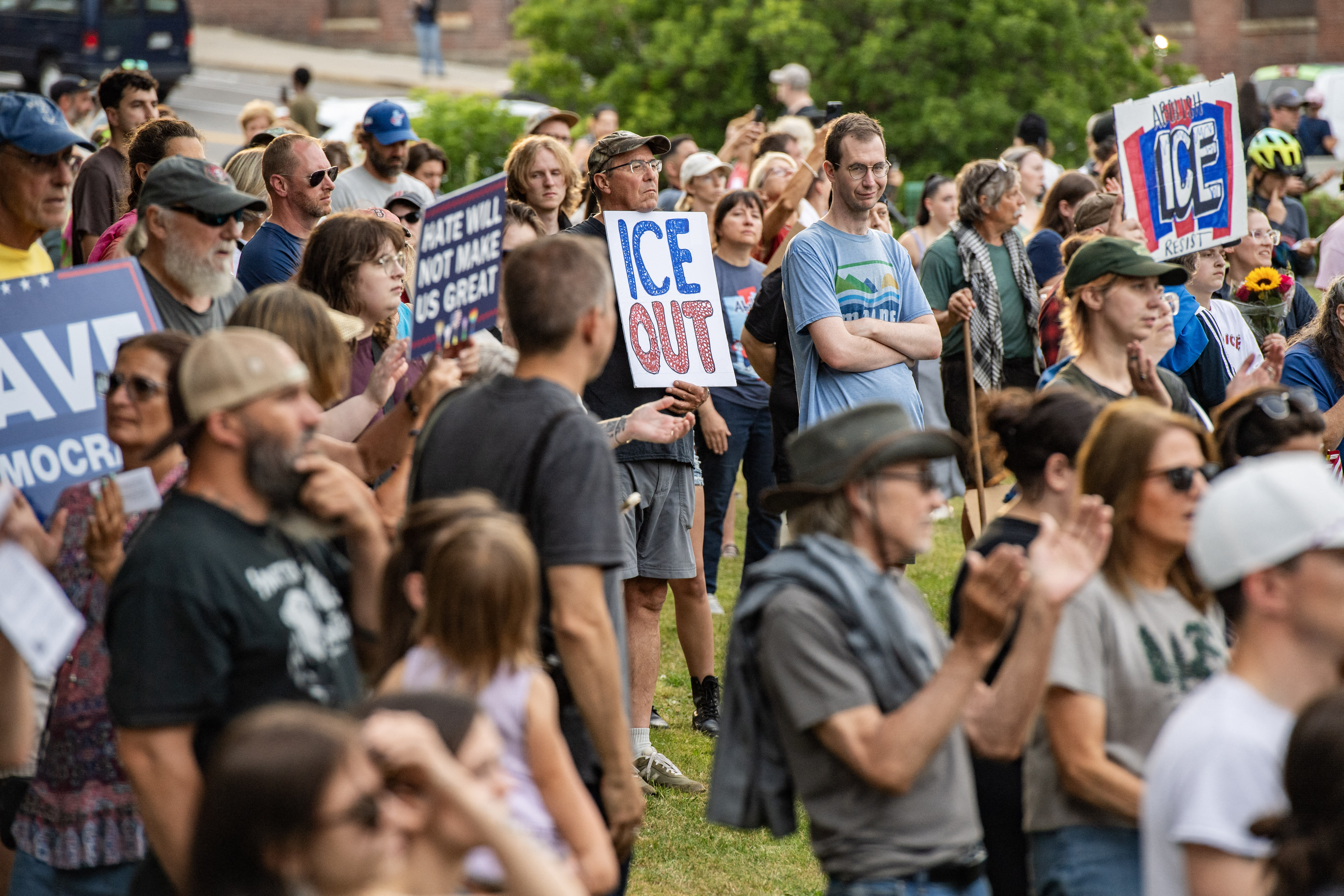 A large crowd gathered in an open area holding protest signs