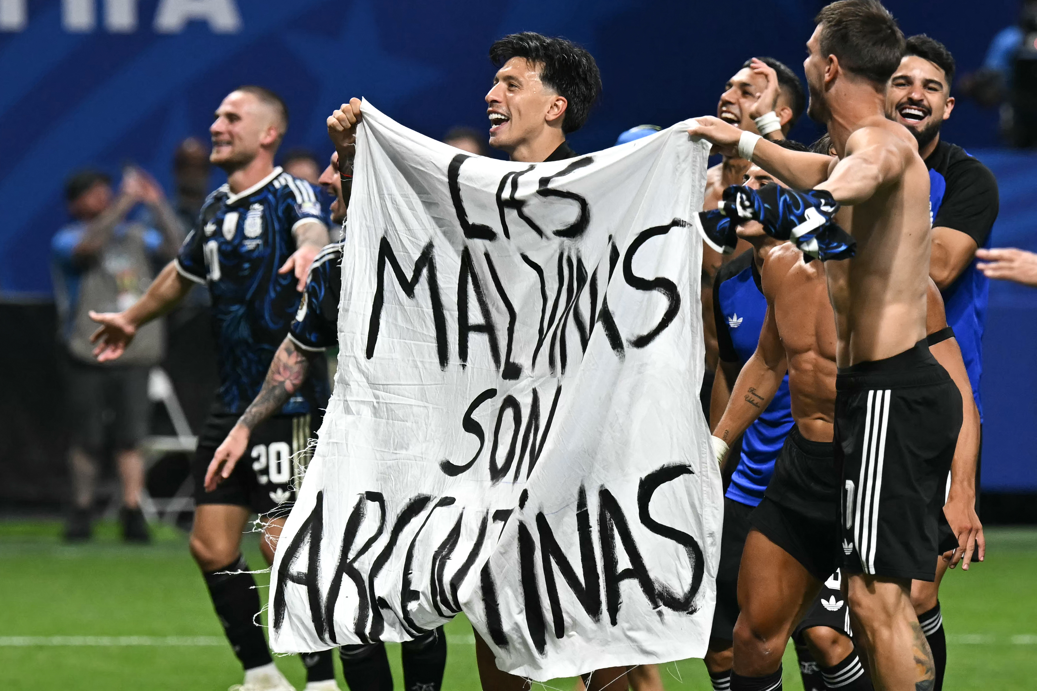 Argentina's players hold a banner reading "The Malvinas (Falkland Islands) belong to Argentina," after winning the 2026 World Cup football tournament semi-final match between England and Argentina at the Atlanta Stadium in Atlanta on July 15, 2026.