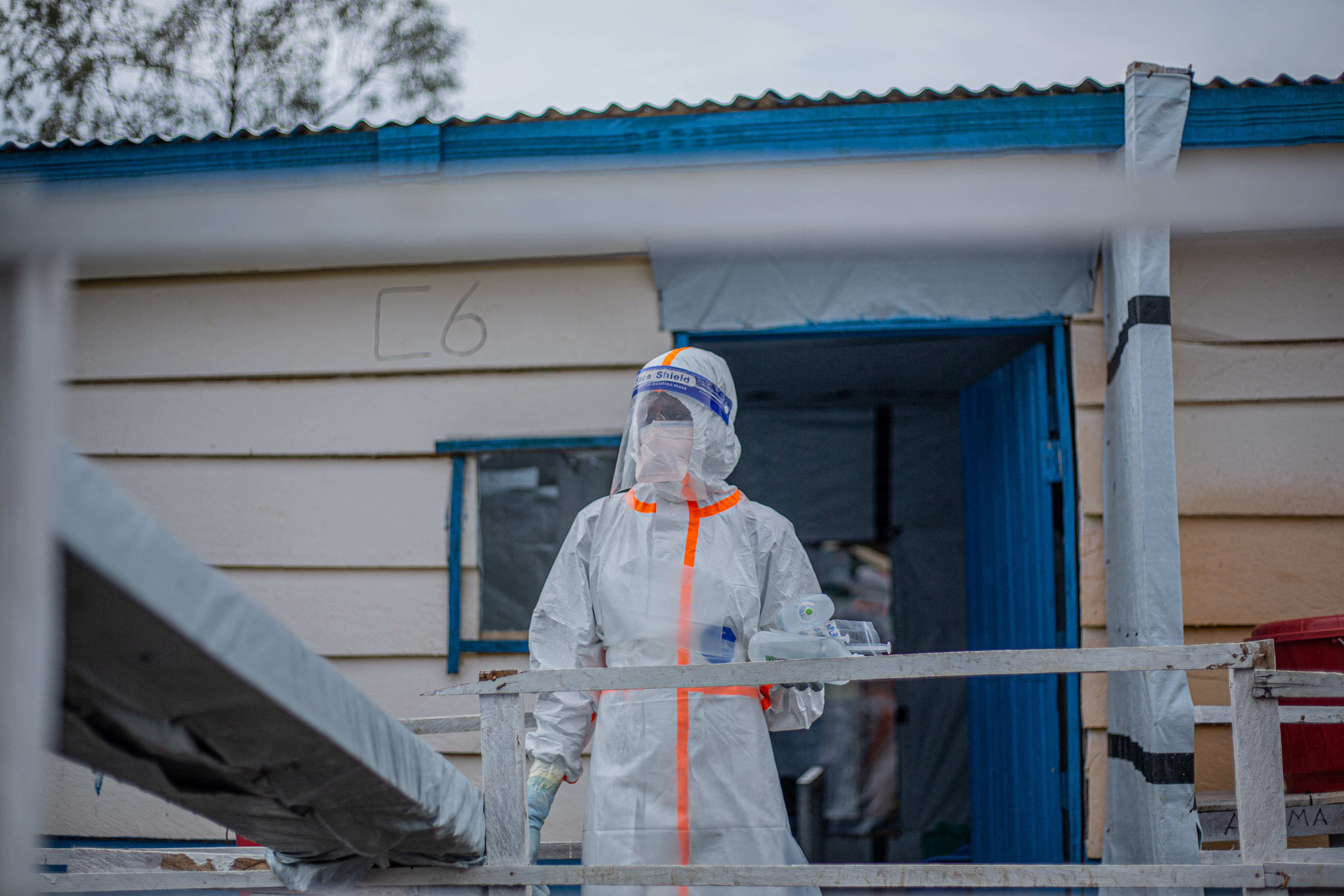 A doctor wearing personal protective equipment (PPE) carries medicines and IV fluid bags for patients at the Rwampara Ebola Treatment Centre (ETC) in Bunia, Ituri, in the east of the Democratic Republic of Congo on July 13, 2026.
