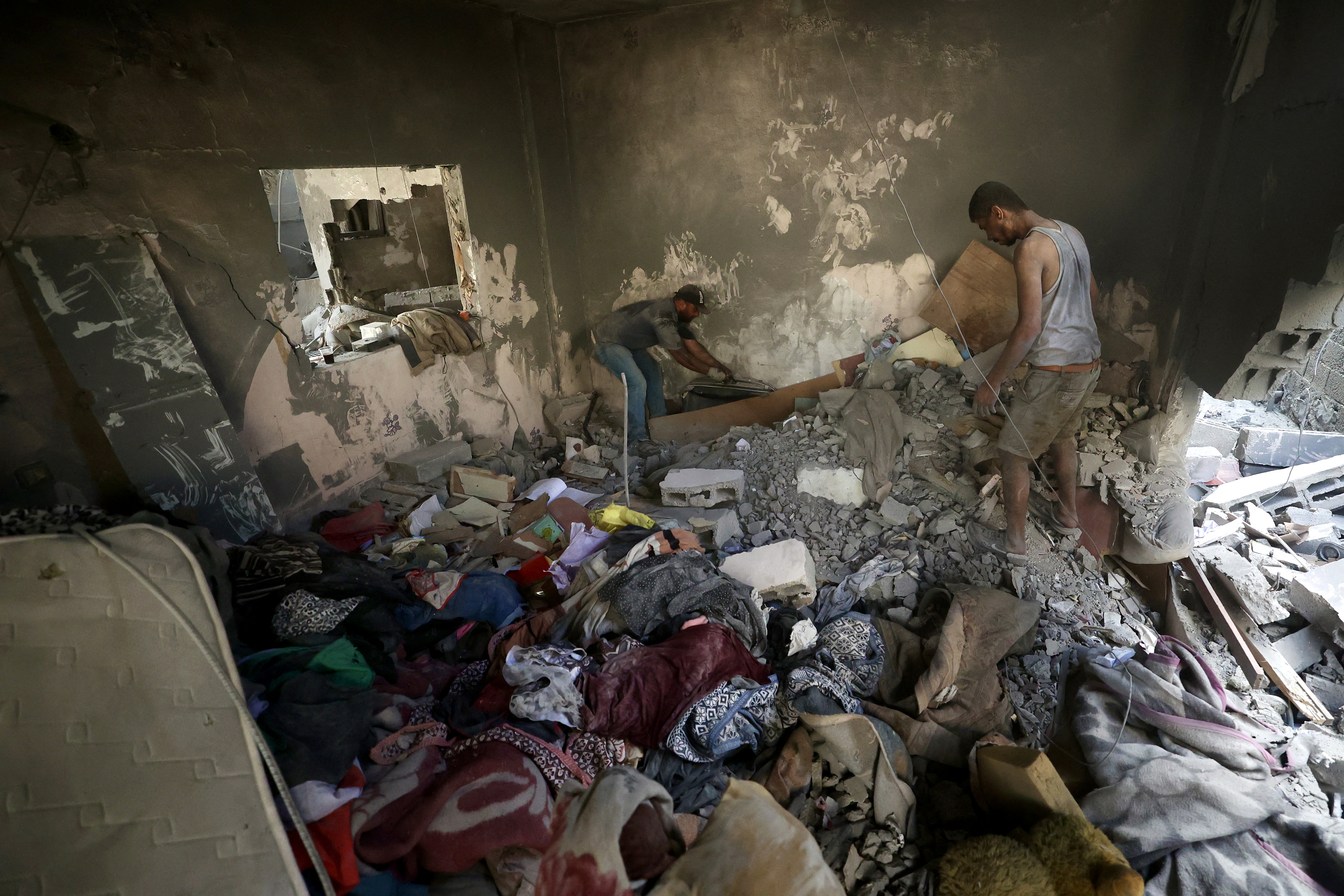 Palestinians look for their belongiongs at the site of an Israeli strike at the Bureij refugee camp in the central Gaza Strip, on July 16, 2026
