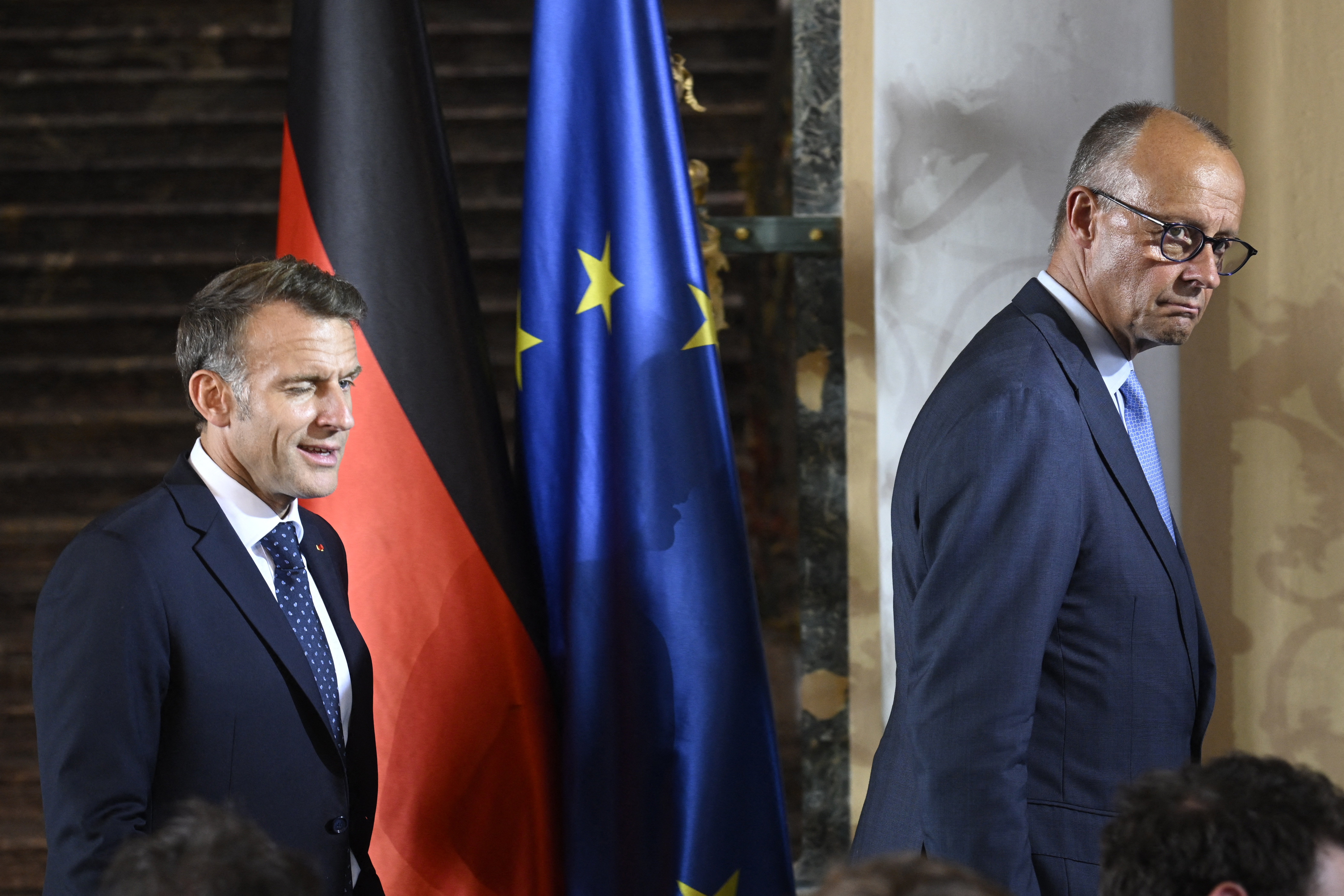 France's President Emmanuel Macron (L) and German Chancellor Friedrich Merz (R) leave after a joint press conference following the 26th German-French cabinet in the Augustusburg castle in Bruehl, western Germany, on July 17, 2026. (Photo by INA FASSBENDER / AFP)
