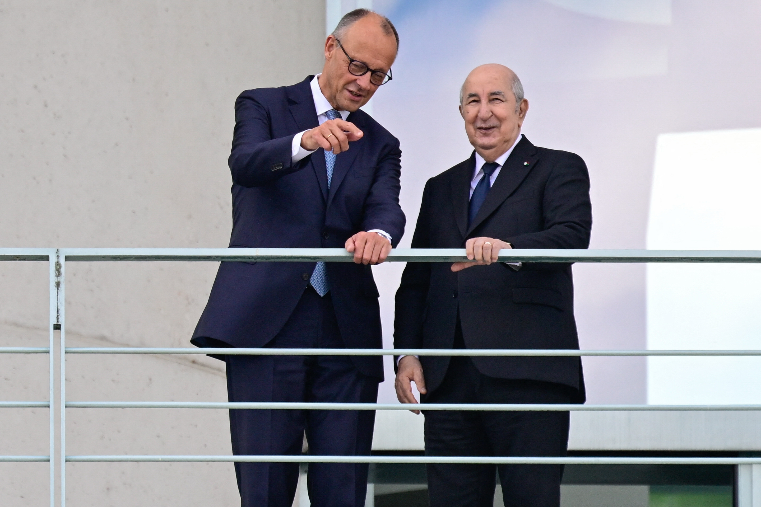 German Chancellor Friedrich Merz (L) and Algeria's President Abdelmadjid Tebboune chat on the terrace of the Chancellery in Berlin on July 16, 2026, prior bilateral talks. (Photo by John MACDOUGALL / AFP)