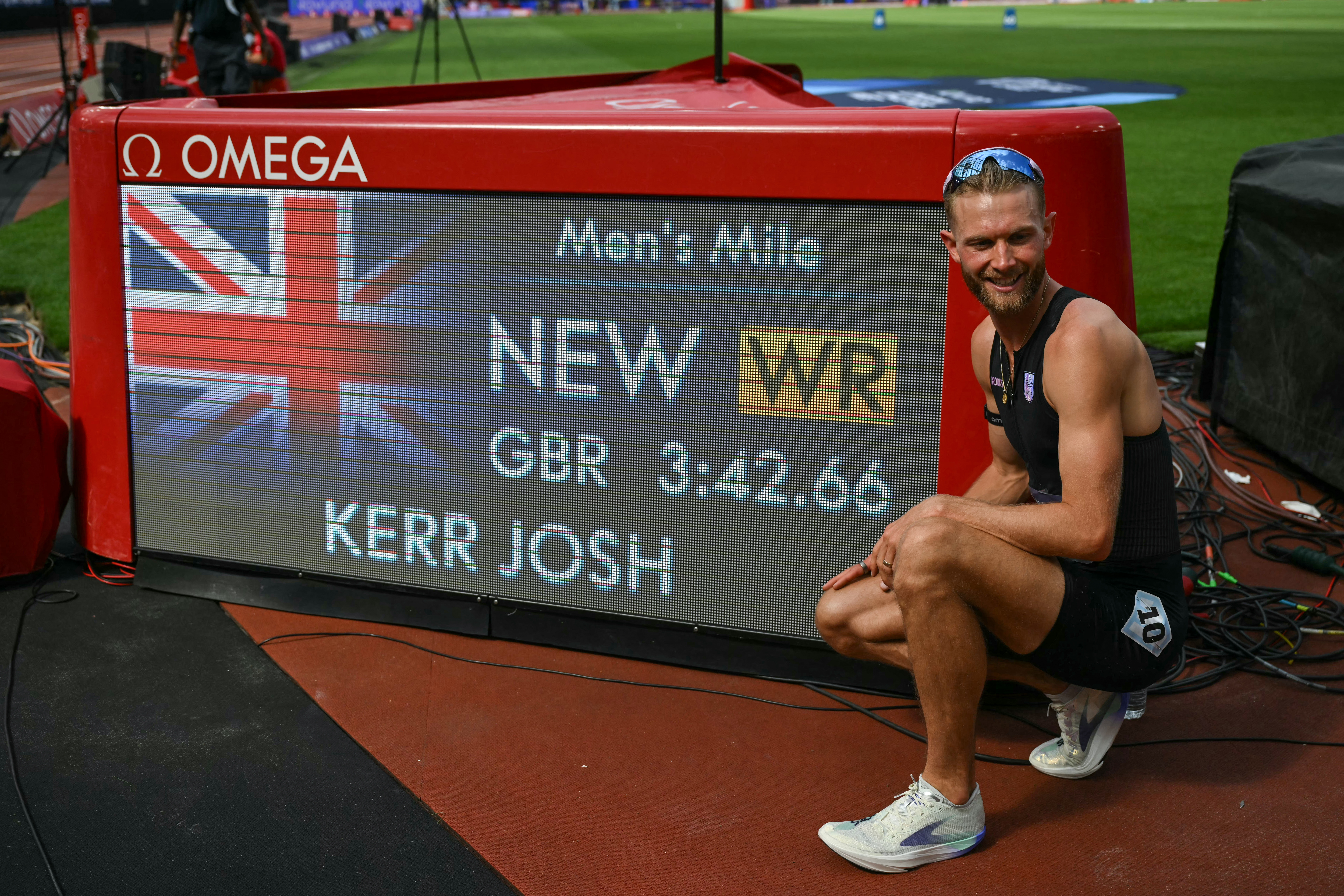 Britain's Josh Kerr poses next to the world record time after winning the men's one mile event during the IAAF Diamond League athletics competition at the London stadium in London on July 18, 2026. (Photo by Glyn KIRK / AFP)