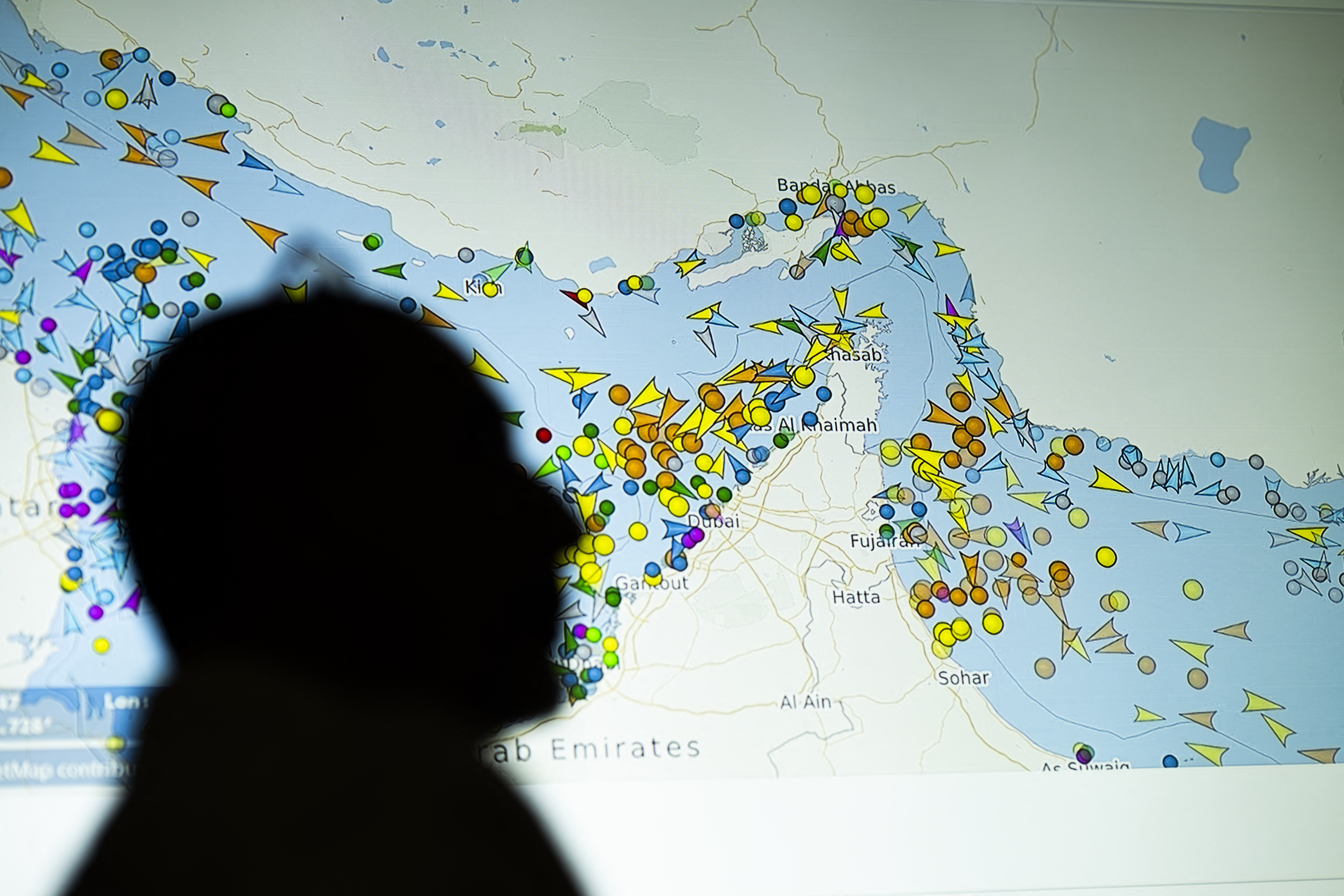 (FILES) A photo illustration taken in Nicosia on May 4, 2026, shows a person in front of a large screen displaying vessel movements in the Strait of Hormuz on a ship-tracking website.