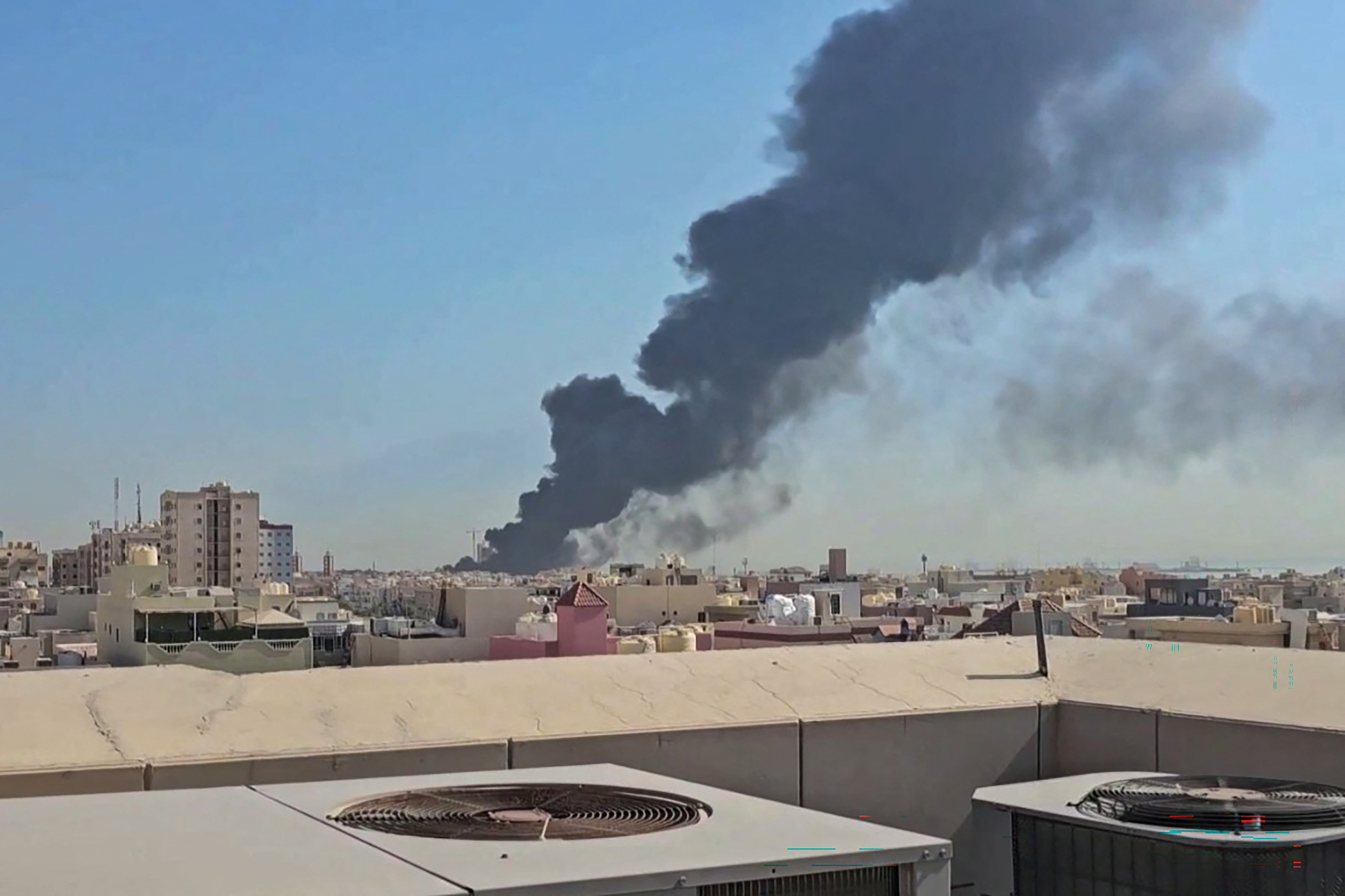 plume of black smoke billowing over the town of Mangaf, south of Kuwait City