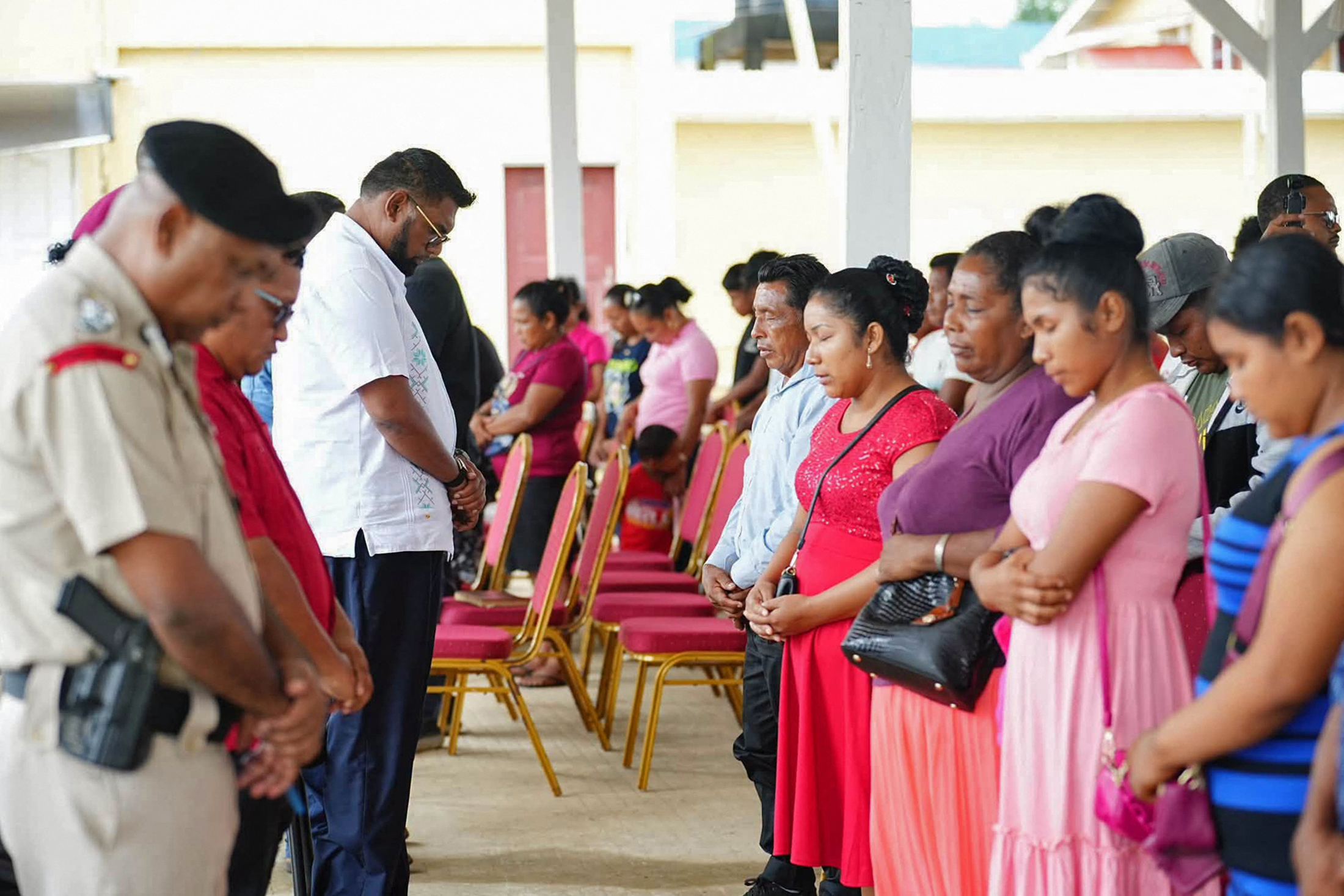 Handout picture released by NCN Guyana showing President Irfaan Ali (L) attending a meeting with some of the survivors and relatives of those still missing after a ferry carrying more than 100 people capsized off the coast of the country, in Mabaruma, Region One, Guyana, on July 20, 2026.