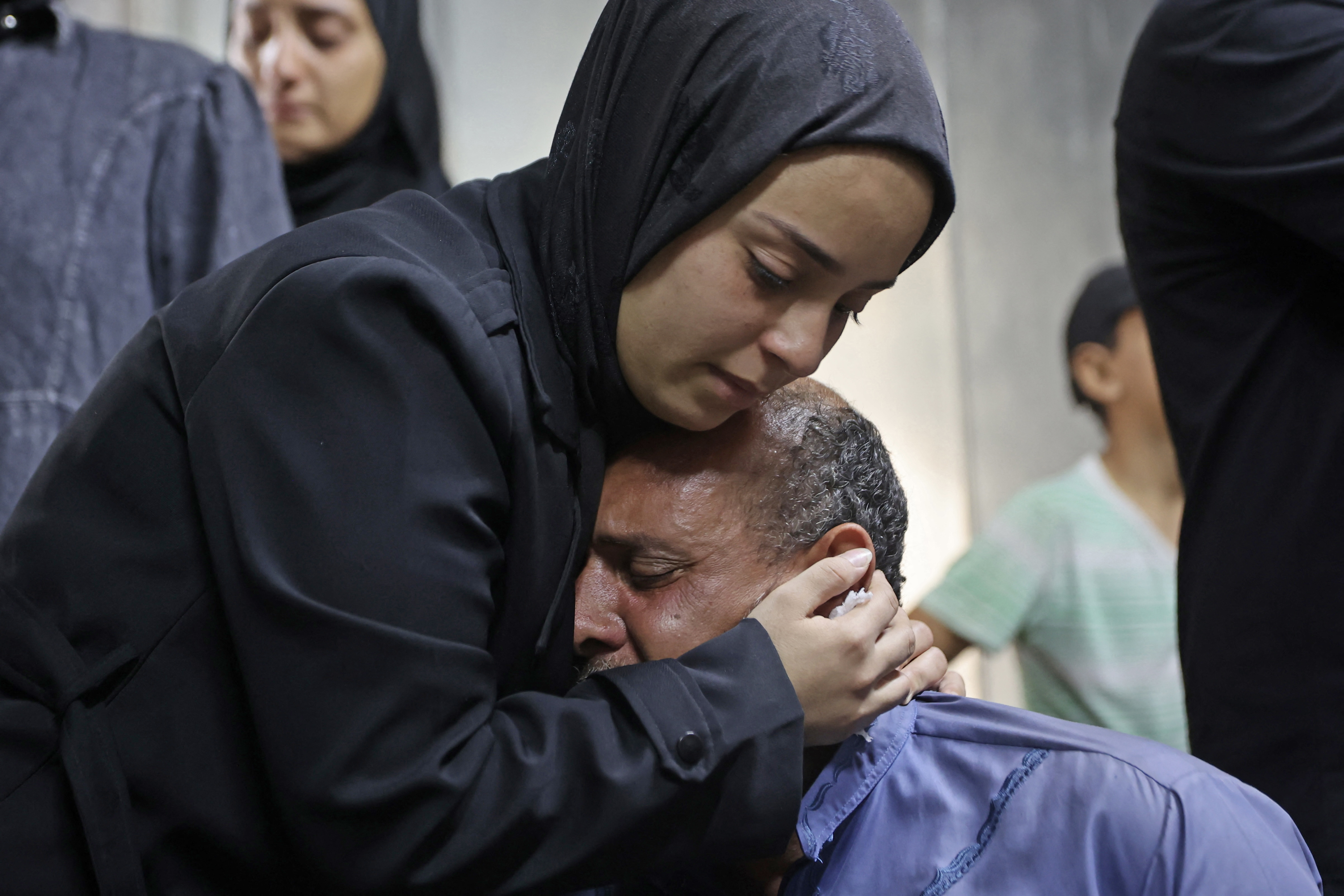 Mourners weep next to the body of one of the Palestinian who died after an Israeli airstrike targeted a residential apartment in the Sabra neighborhood of Gaza City on July 21, 2026.