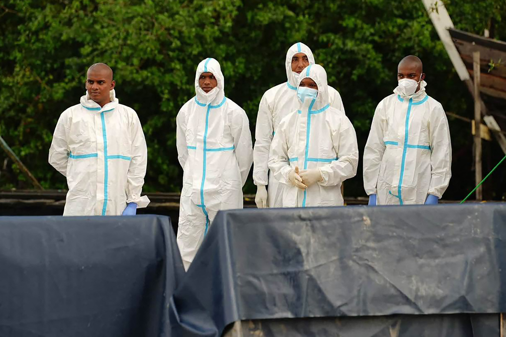 Handout picture released by NCN Guyana showing forensic personnel by the waterfront in Charity, Guyana, on July 21, 2026, after the capsizing of a ferry.