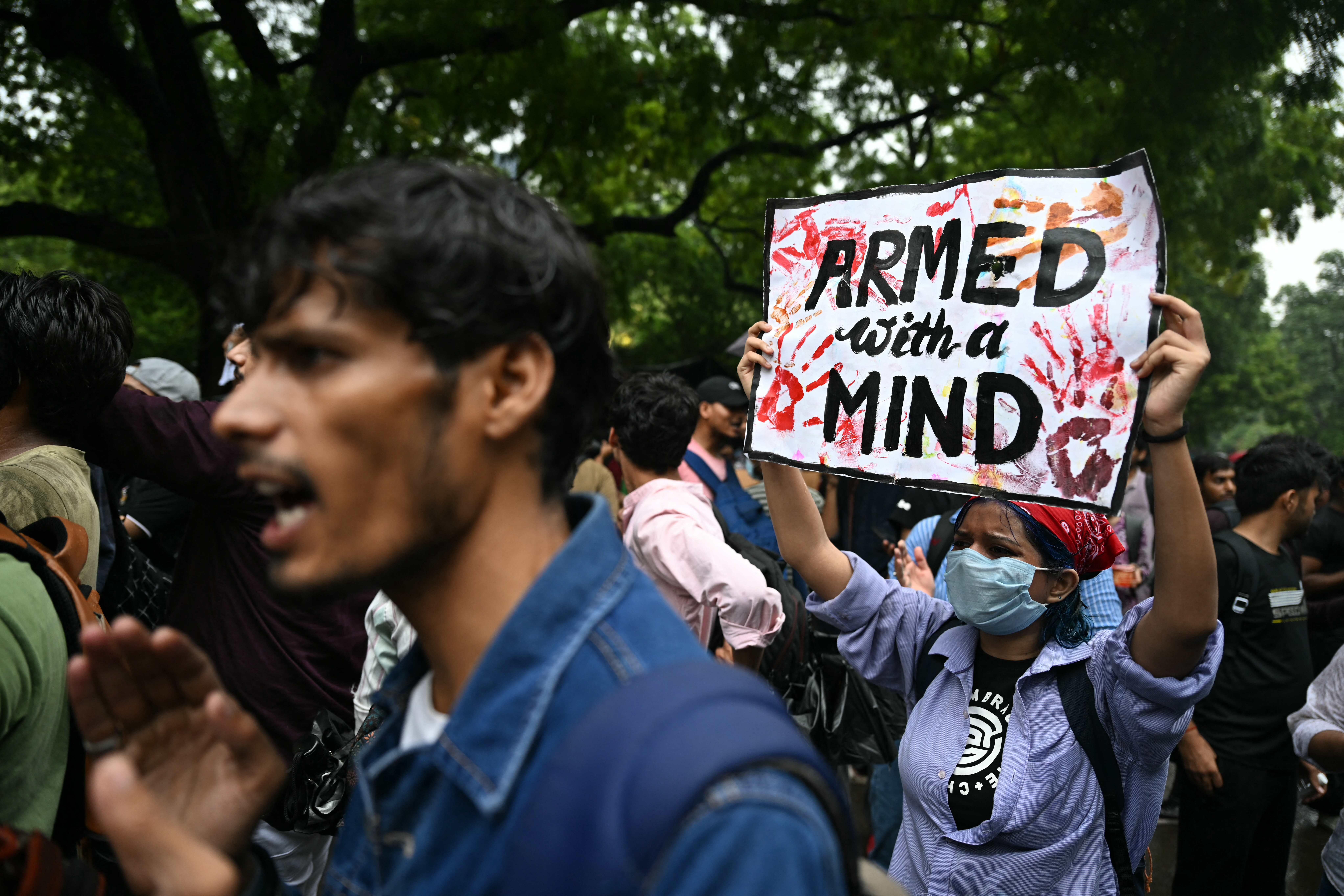 A Cockroach Janta Party (CJP) supporter holds a placard at Jantar Mantar in New Delhi