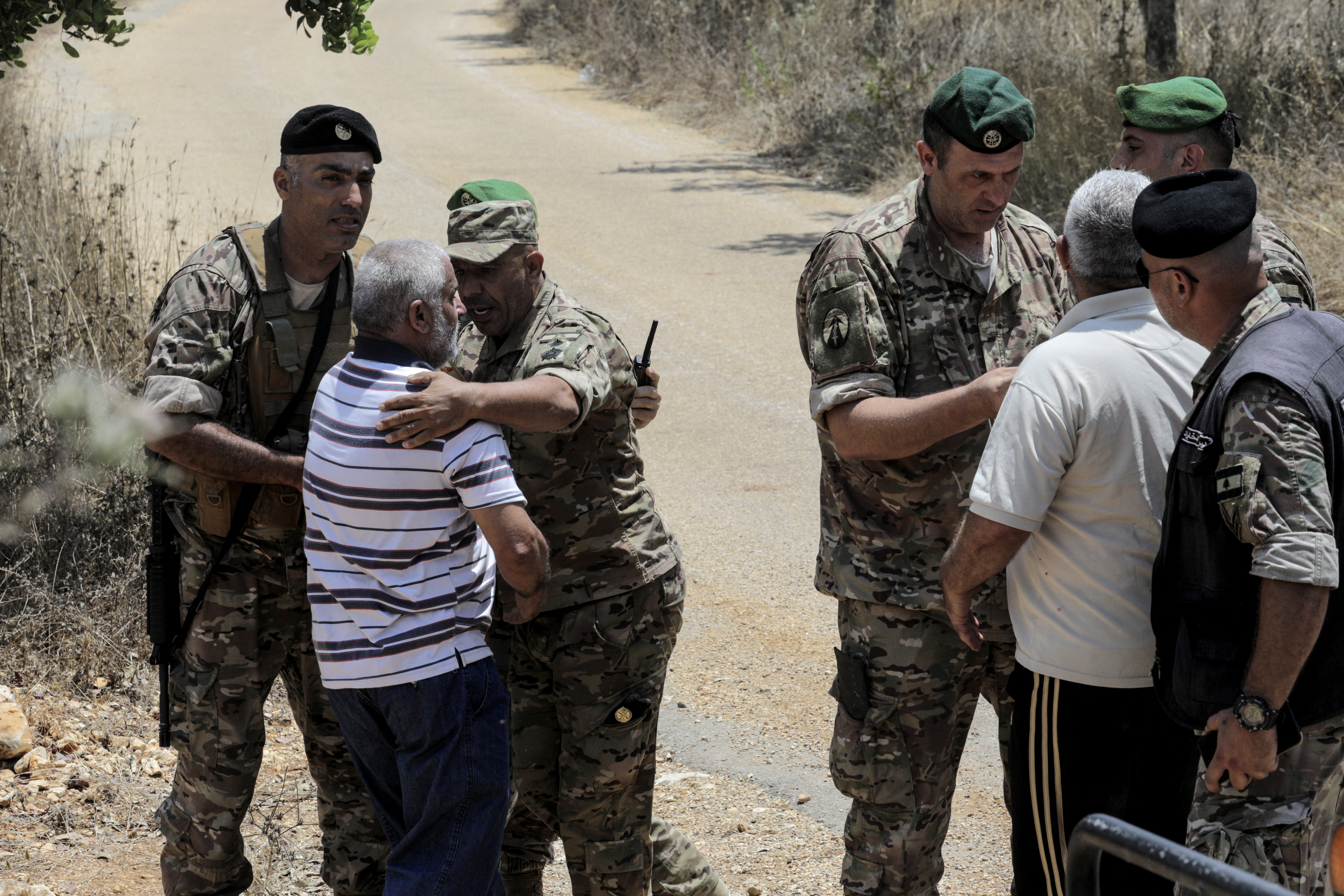 Lebanese soldiers speak with residents waiting at the entrance to Zawtar al-Gharbiya for permission to go check on their homes on July 22, 2026, after the army deployed to the southern village.