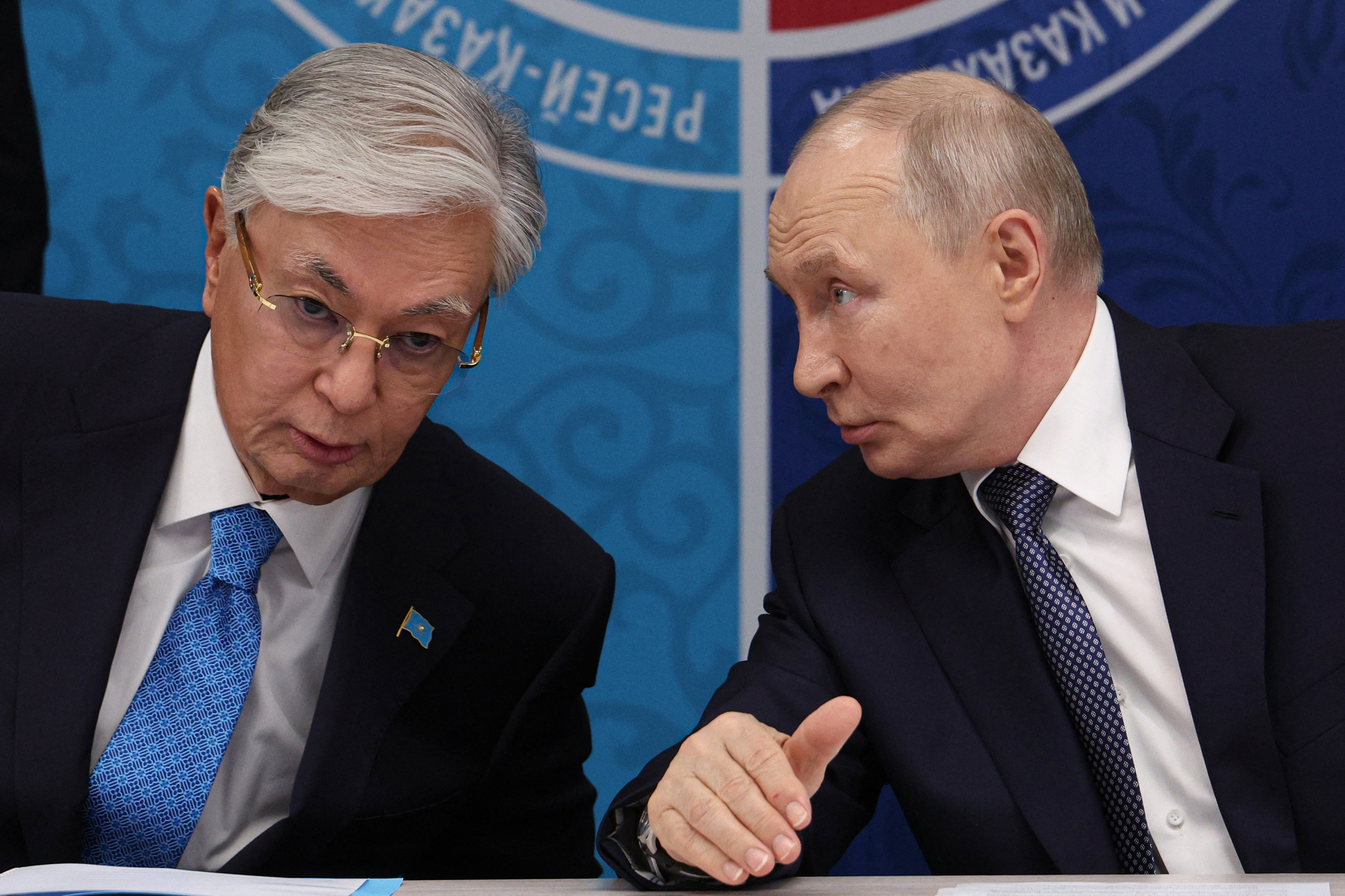 In this pool photograph distributed by the Russian state agency Sputnik, Russia's President Vladimir Putin (R) speaks to Kazakhstan's President Kassym-Jomart Tokayev as they attend the 22nd Russia-Kazakhstan Forum of Interregional Cooperation in Omsk on July 25, 2026.