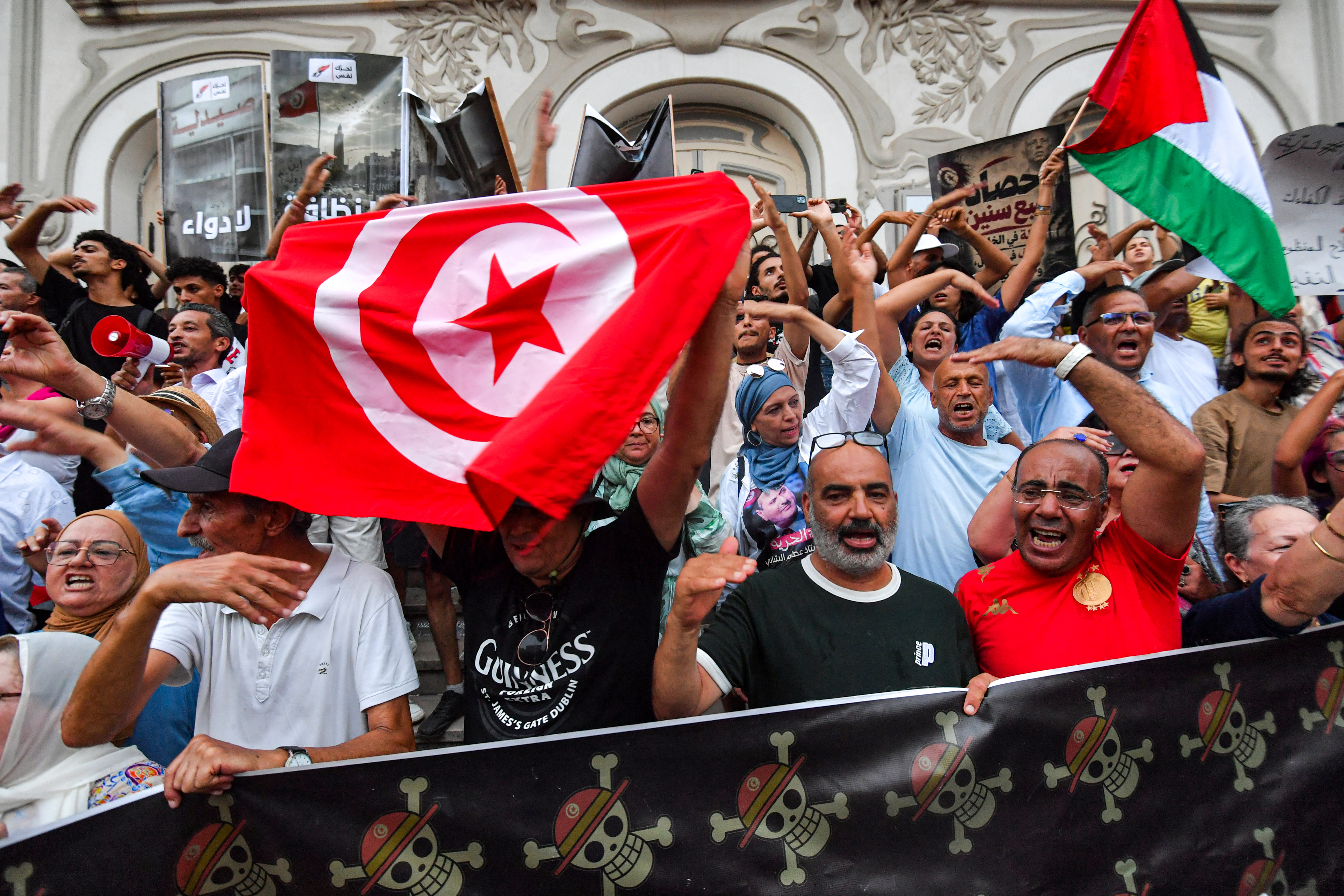People gather to protest Tunisia's President Kais Saied during a demonstration marking five years since his suspension of parliament and assumption of emergency powers, along Avenue Habib Bourguiba in Tunis on July 25, 2026.