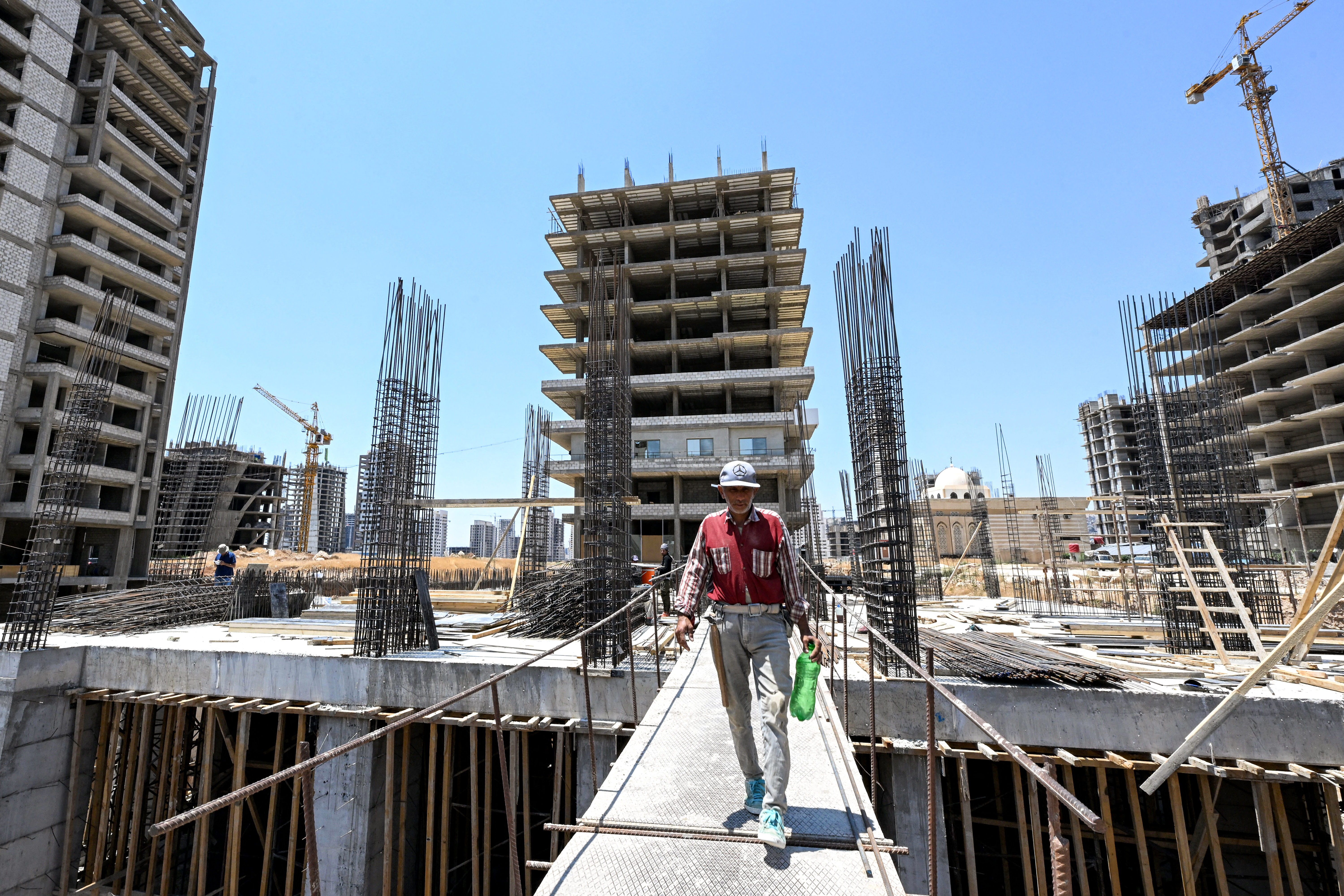 A worker walks at a construction site in Marota City, a new mixed-use development project near the Umayyad Square in Damascus on July 22, 2026.