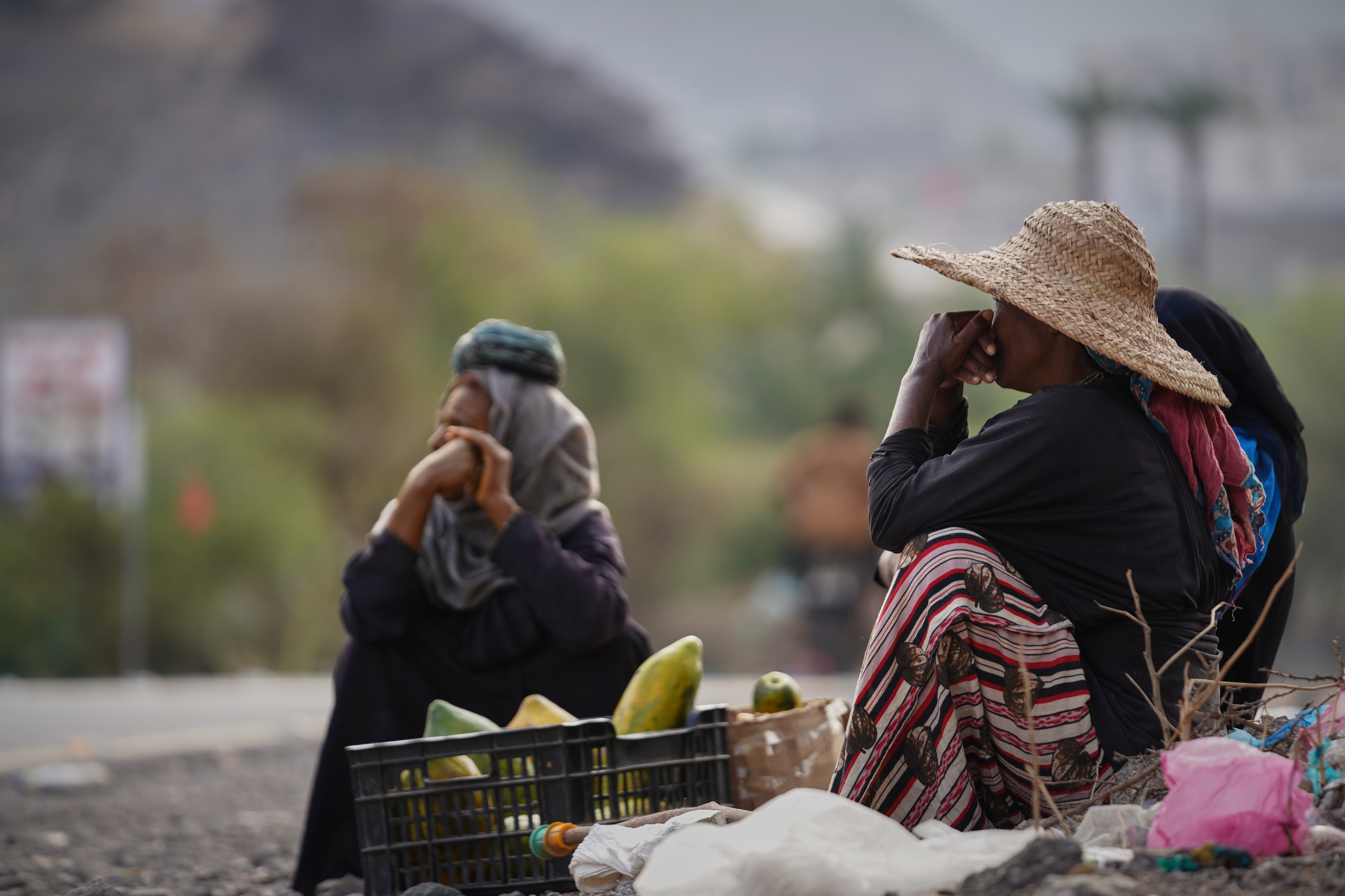 Yemeni women sit along a road serving as the sole artery connecting the city of Taiz to the outside world and a vital economic lifeline for residents as they sell fruit to travelers, Friday, March 13, 2026. (AP Photo/Abdulnasser Alseddik)