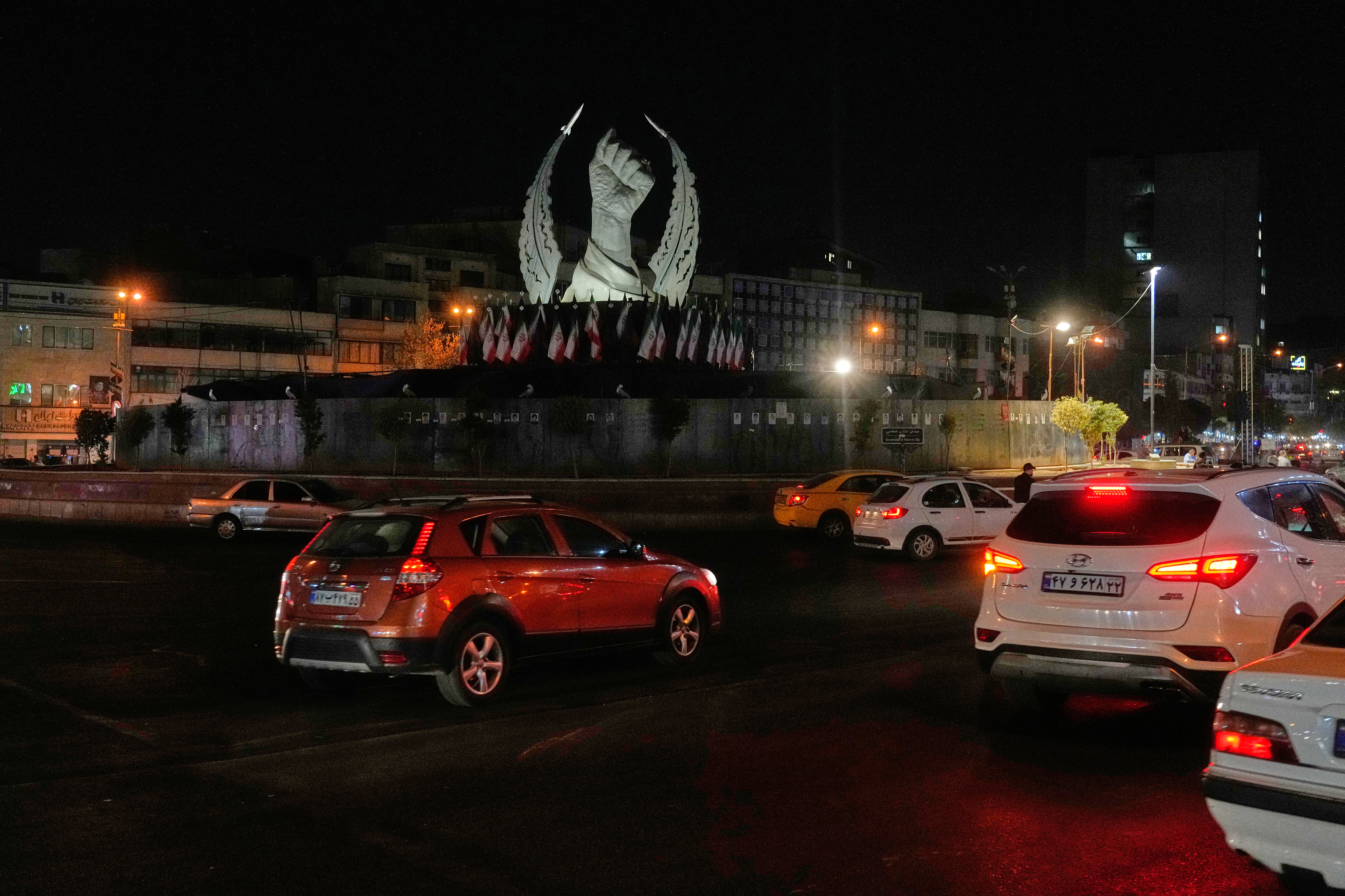 Vehicles drive past a monument depicting the clenched fist of the late Iranian Supreme Leader Ayatollah Ali Khamenei, who was killed in the U.S. and Israel strike on Feb. 28, in Islamic Revolution Square in Tehran, Sunday, July 19, 2026. (AP Photo/Vahid Salemi)