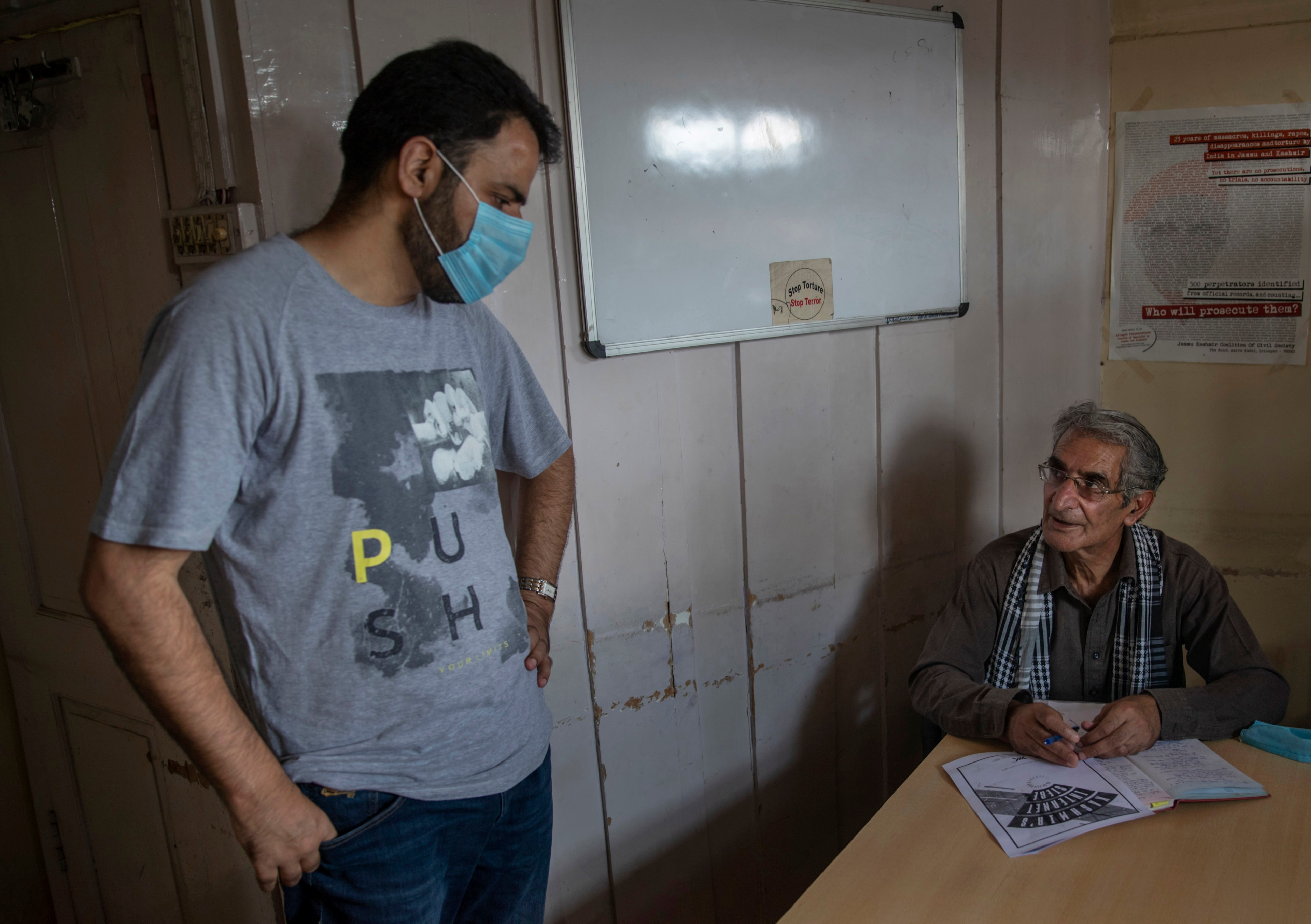 FILE- Khurram Parvez, a prominent human rights activist, left, speaks with human rights lawyer Parvez Imroz inside the office of of the Jammu Kashmir Coalition of Civil Society in Srinagar, Indian controlled Kashmir, Aug. 25, 2020. (AP Photo/Dar Yasin, File)