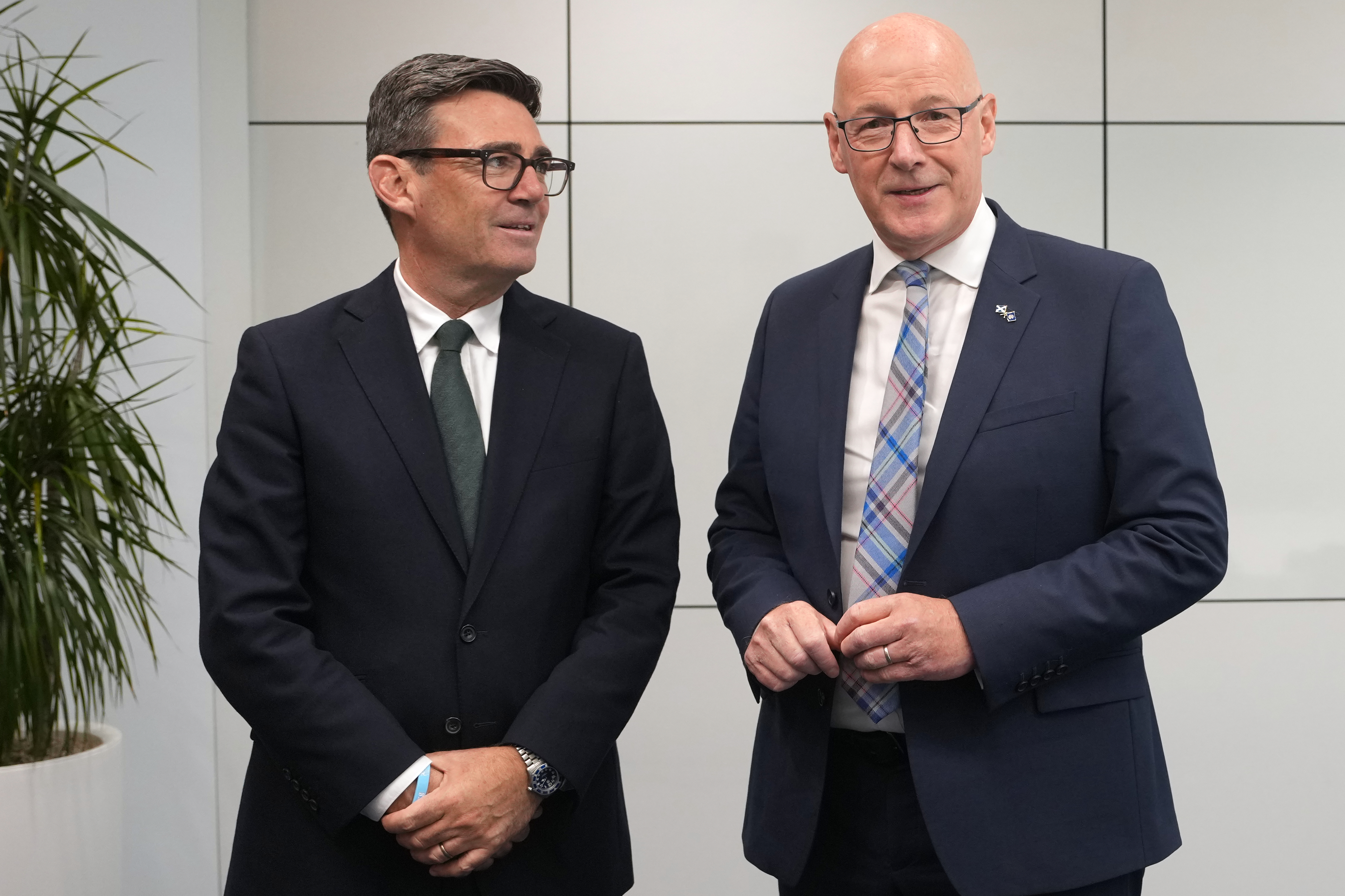 Two men in suits stand next to each other