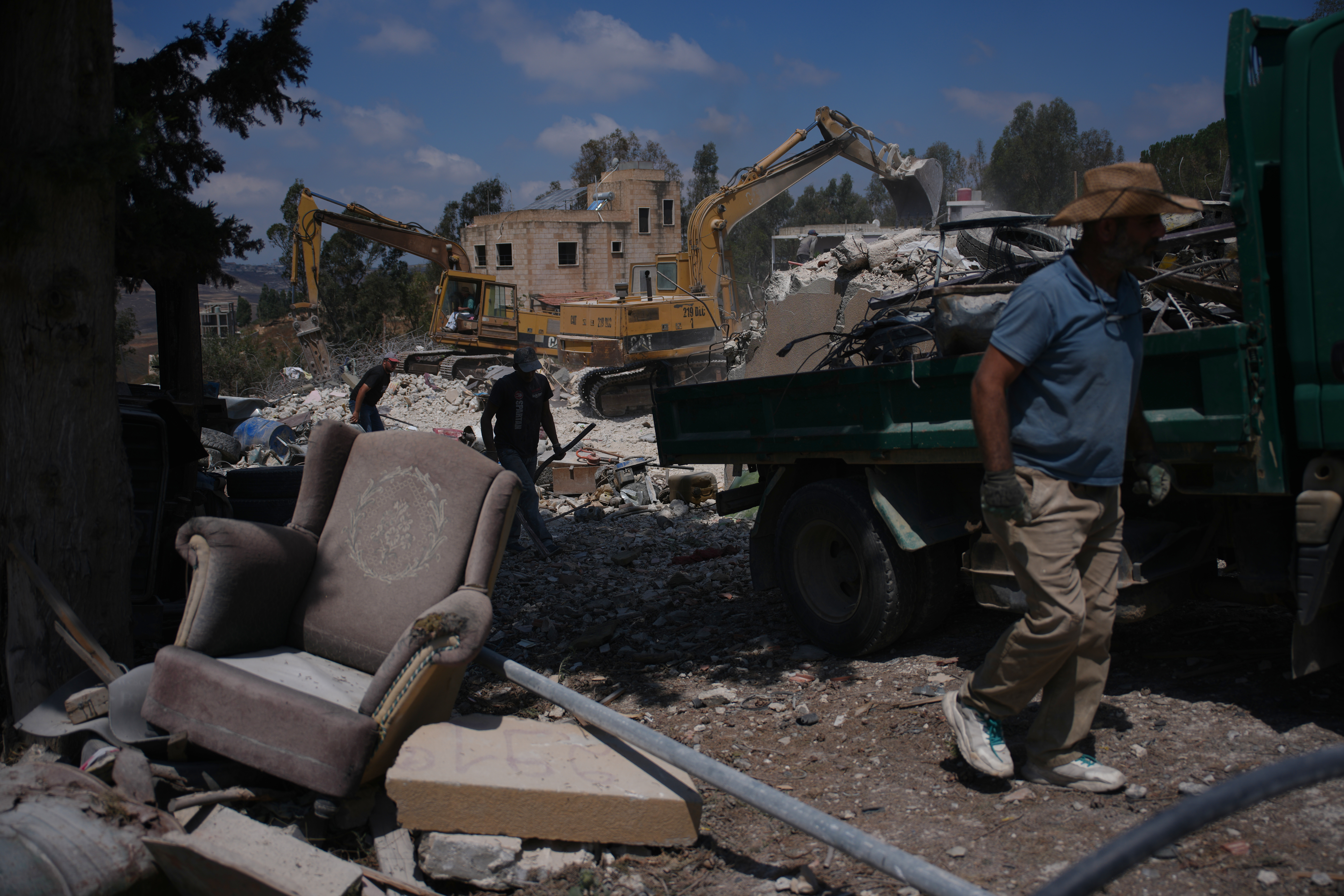 Residents clear rubble from their homes destroyed during the Israel-Hezbollah war in Ghandouriyeh village, southern Lebanon, Tuesday, July 21, 2026. (AP Photo/Hassan Ammar)