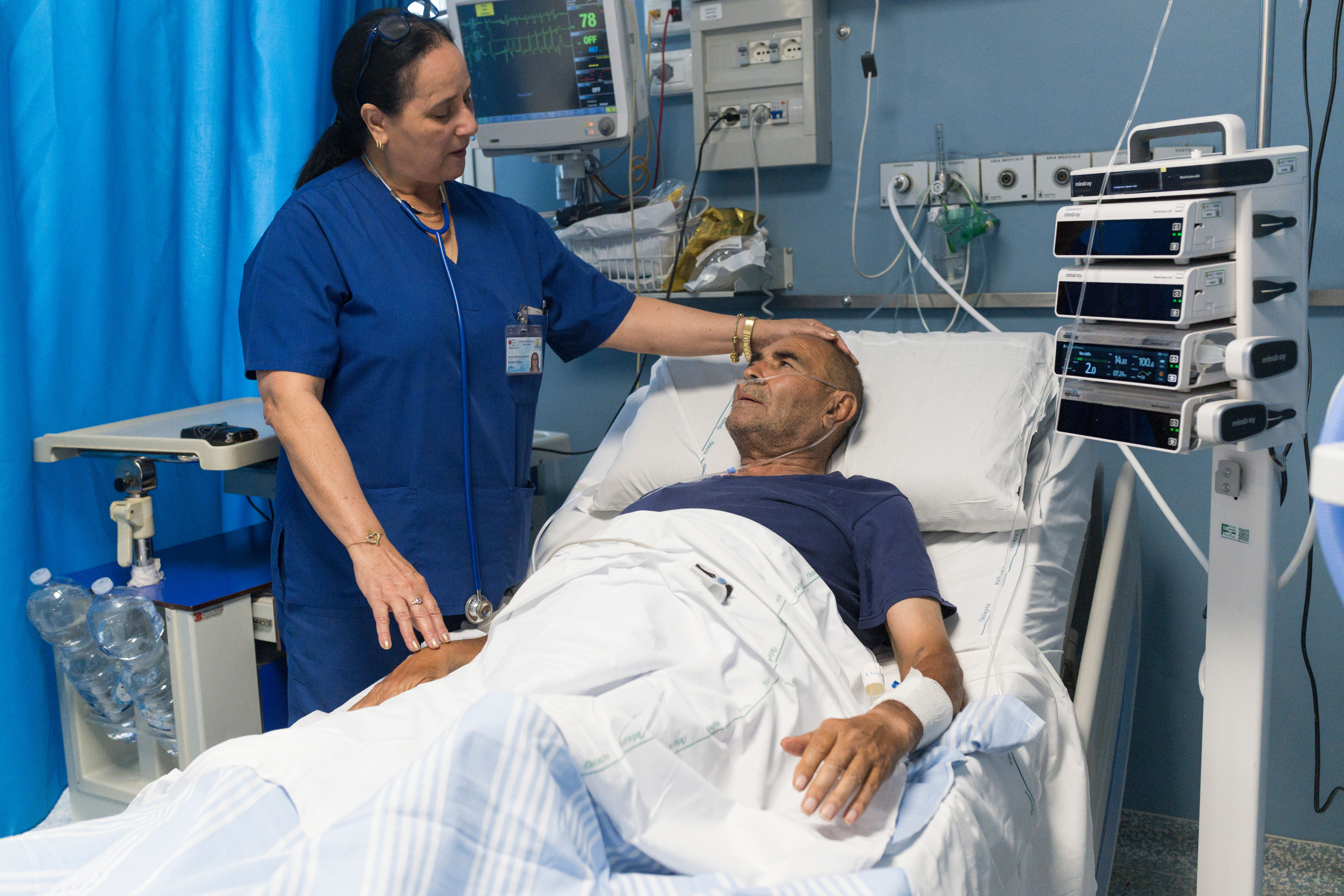 Cuban doctor Daysi Luperon Loforte talks with Teodoro Crea, a patient hospitalized in the emergency unit of the Santa Maria degli Ungheresi Hospital of Polistena, in the southern Italian Calabria region, June 16, 2026. (AP Photo/Valeria Ferraro)