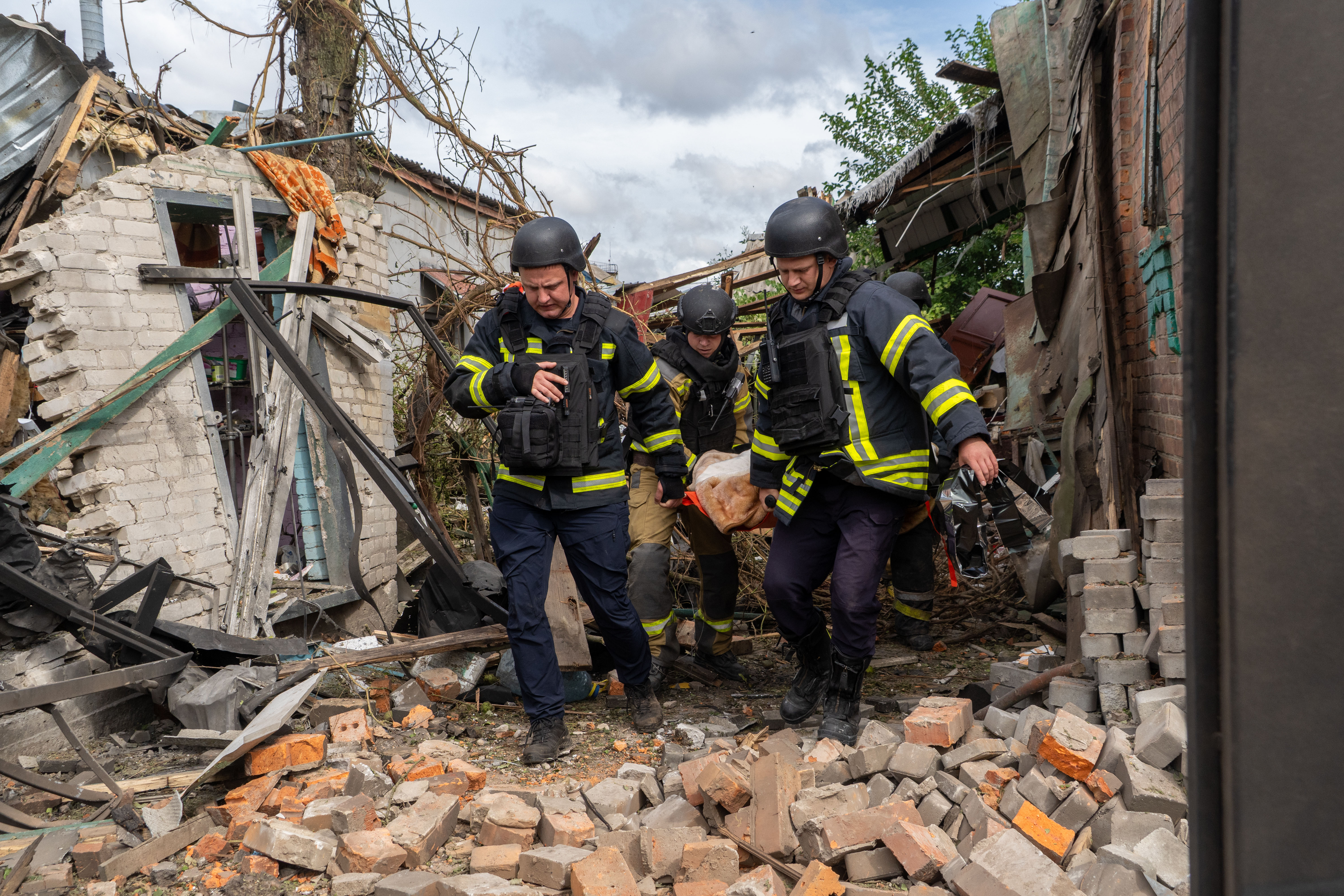 Rescuers carry a body that they removed from under the rubble of an private house following a drone attack from Russia, in Kharkiv, Ukraine, Sunday, July 26, 2026. (AP Photo/Andrii Marienko)