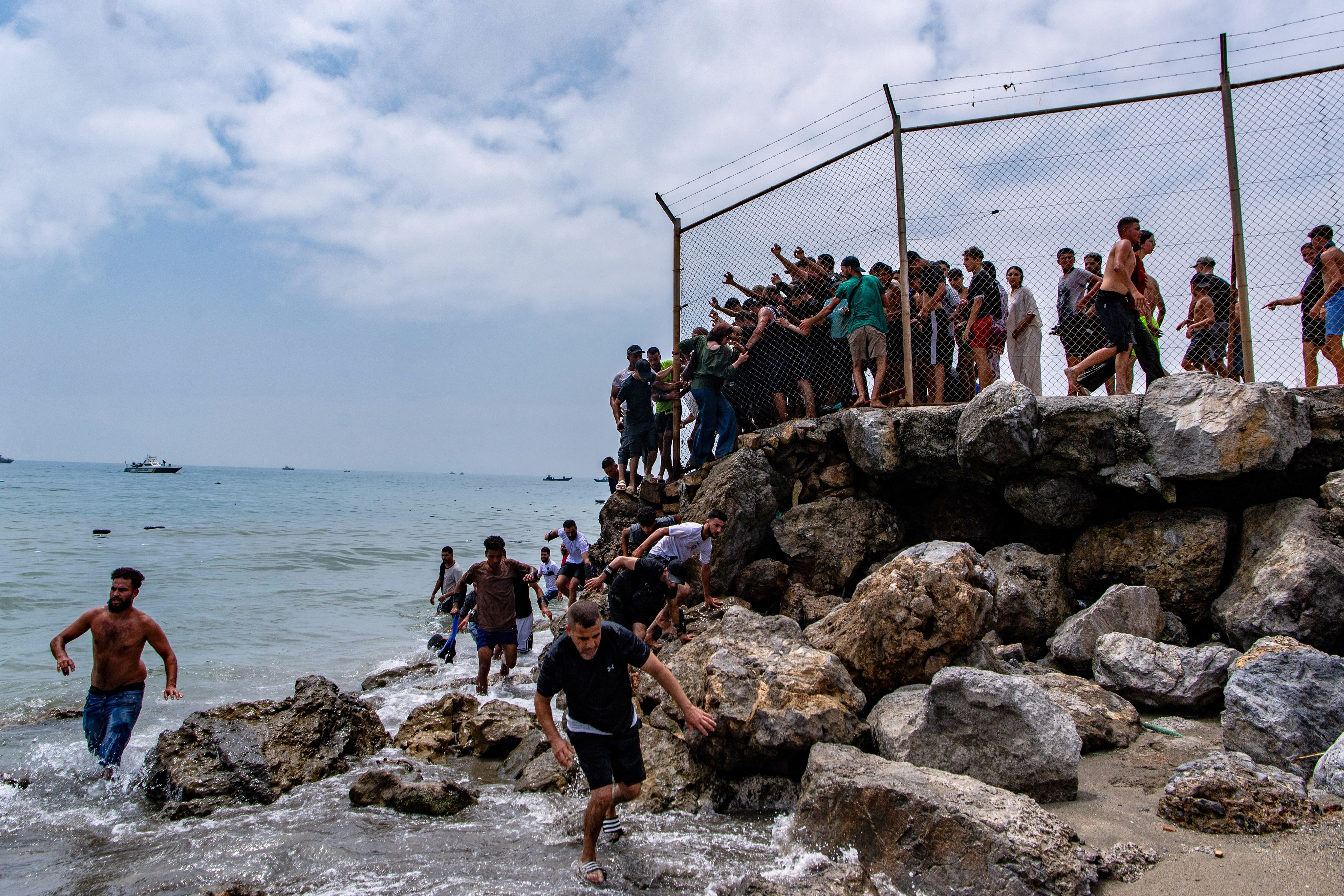 Migrants cross from Morocco into the Spanish enclave of Ceuta, Thursday, July 30, 2026. (AP Photo/Antonio Sempere)