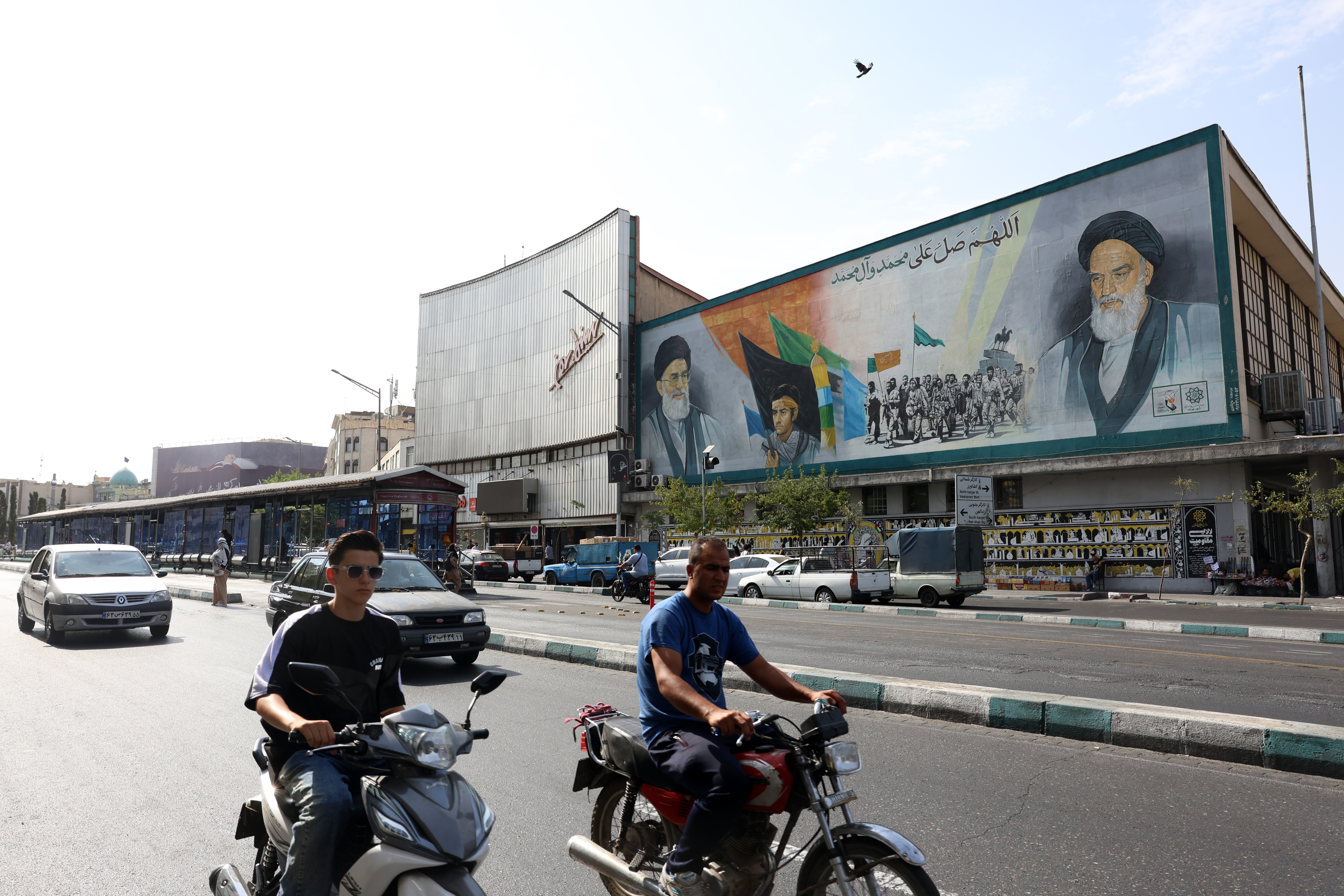 epa13126436 Iranians drive past a mural depicting late Iranian Supreme Leaders Ayatollah Ali Khamenei (L) and Ayatollah Ruhollah Khomeini (R) in Tehran, Iran, 22 July 2026. Tensions between Iran and the US continue over the Strait of Hormuz following US strikes on several locations across Iran. EPA/ABEDIN TAHERKENAREH RESTRICTIONS: NO Access Israel Media/Persian Language TV Stations Outside Iran/Strictly No Access BBC Persian/VOA Persian/Manoto TV/Iran International TV. (As mandated by Iran's Directorate General for Foreign Media) --