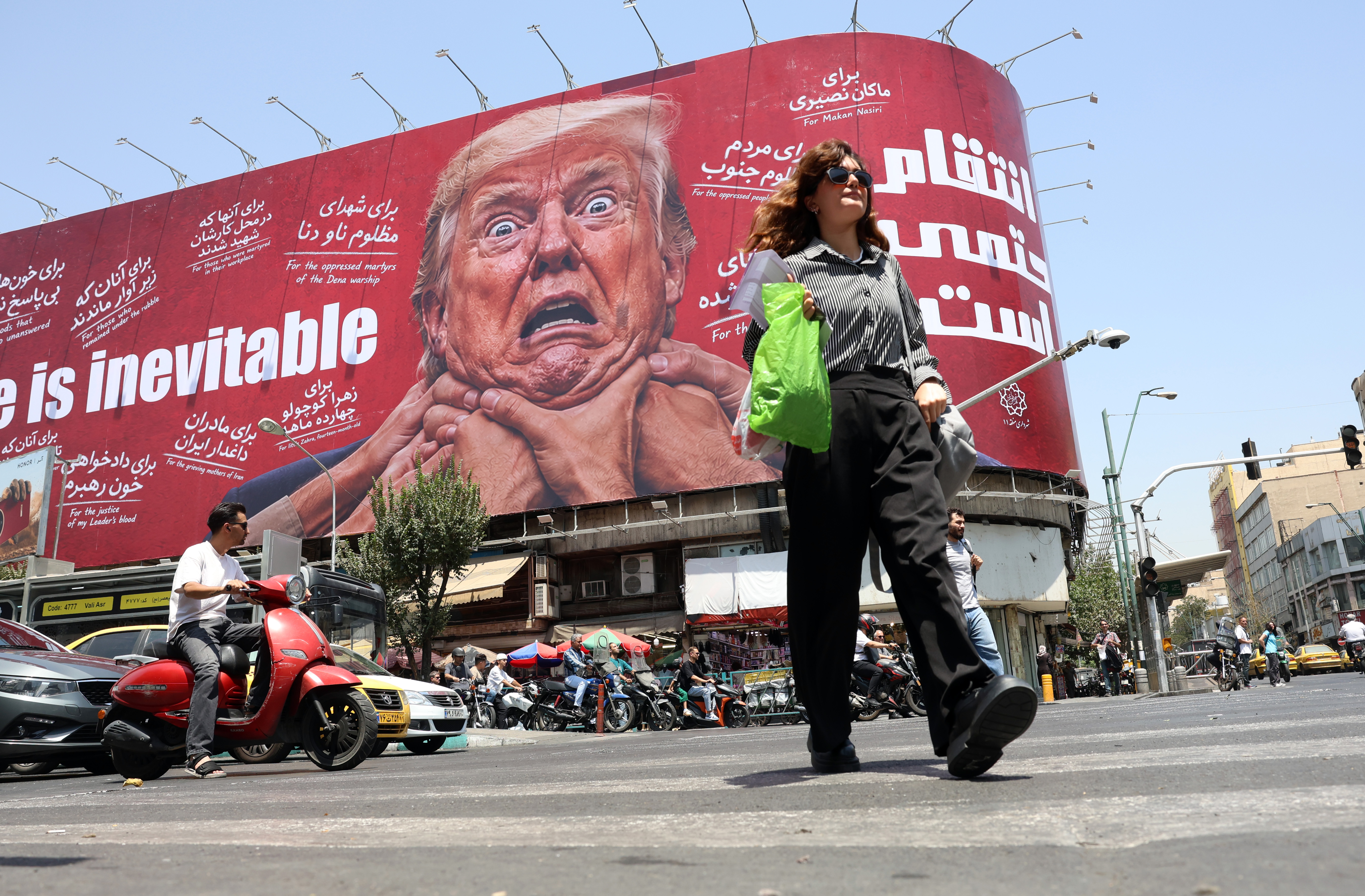 epa13135553 A woman walks past an anti-US and Trump billboard in a street in Tehran, Iran, 27 July 2026. The US and Iran paused strikes and retaliatory attacks to pursue diplomatic efforts to end the conflict over the Strait of Hormuz. EPA/ABEDIN TAHERKENAREH RESTRICTIONS: NO Access Israel Media/Persian Language TV Stations Outside Iran/Strictly No Access BBC Persian/VOA Persian/Manoto TV/Iran International TV. (As mandated by Iran's Directorate General for Foreign Media) --