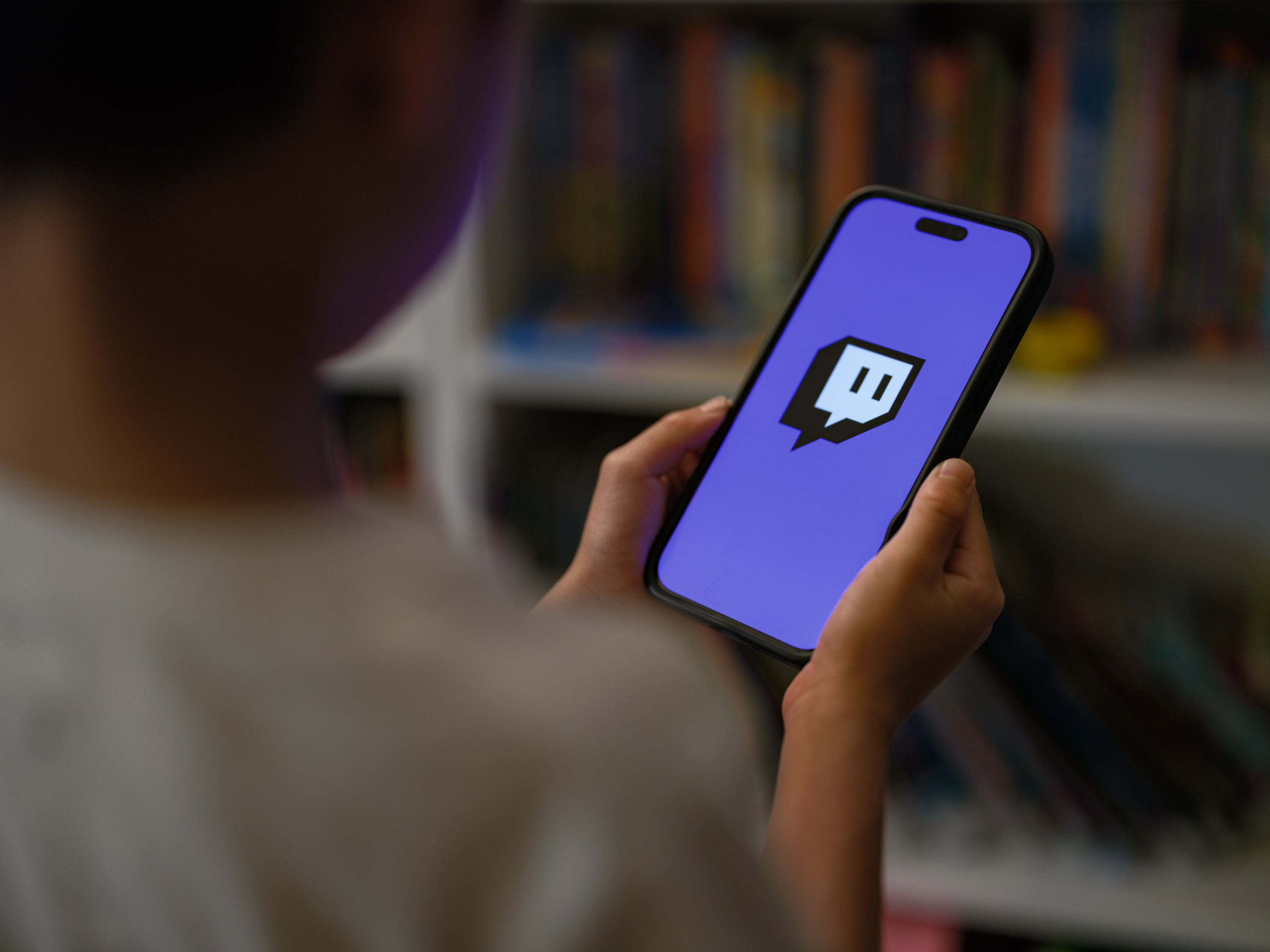 SYDNEY, AUSTRALIA - DECEMBER 07: A 7-year-old teenage boy looks at a phone screen with Twitch logo is displayed on December 07, 2025 in Sydney, Australia. The Online Safety Amendment (Social Media Minimum Age) Act 2024 requires social media platforms, including TikTok, Instagram, Facebook, YouTube, Snapchat, X, Reddit, Threads, Twitch, and Kick to implement age-verification systems and take reasonable steps to prevent account creation by users under 16, with non-compliant platforms facing penalties of up to A$50 million. (Photo by George Chan/Getty Images)